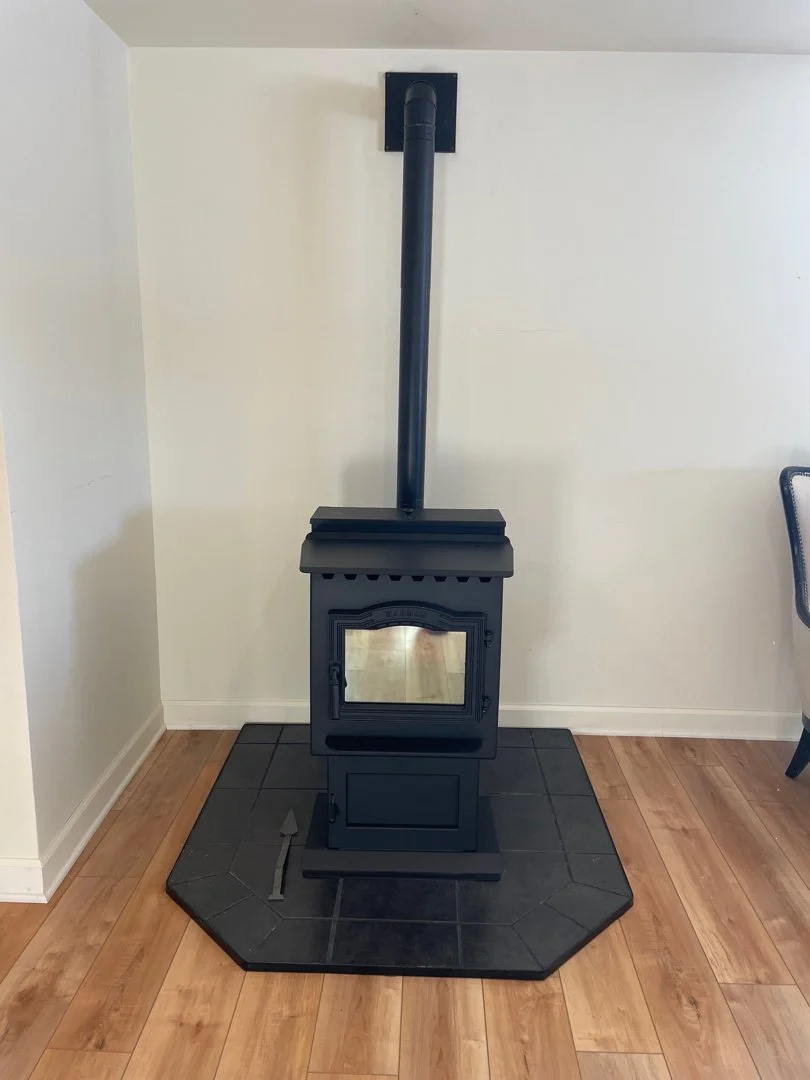 black pellet stove on black marble stand