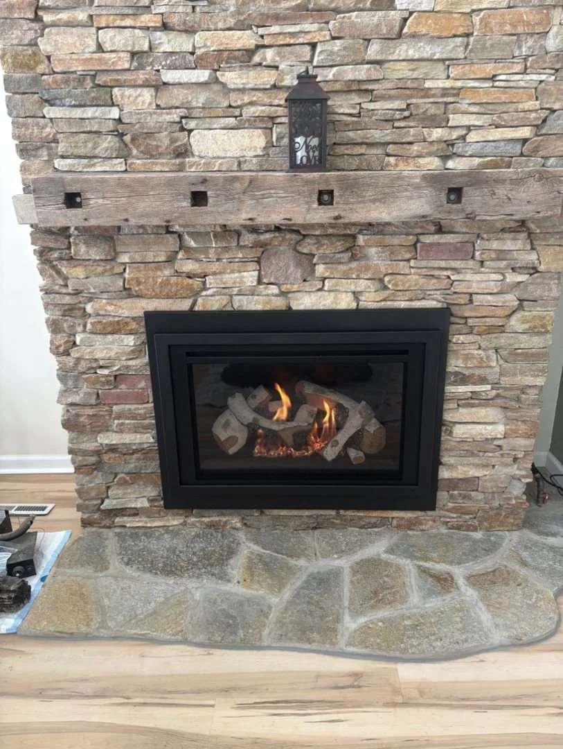 heat n glo gas insert with a brick surround and stone flooring