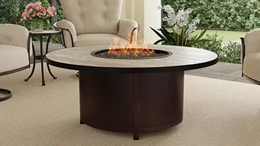 brown circular firepit on a porch with flowers