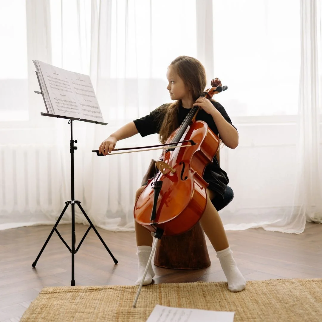 NUVO Music School student is playing cello while looking at the music sheet