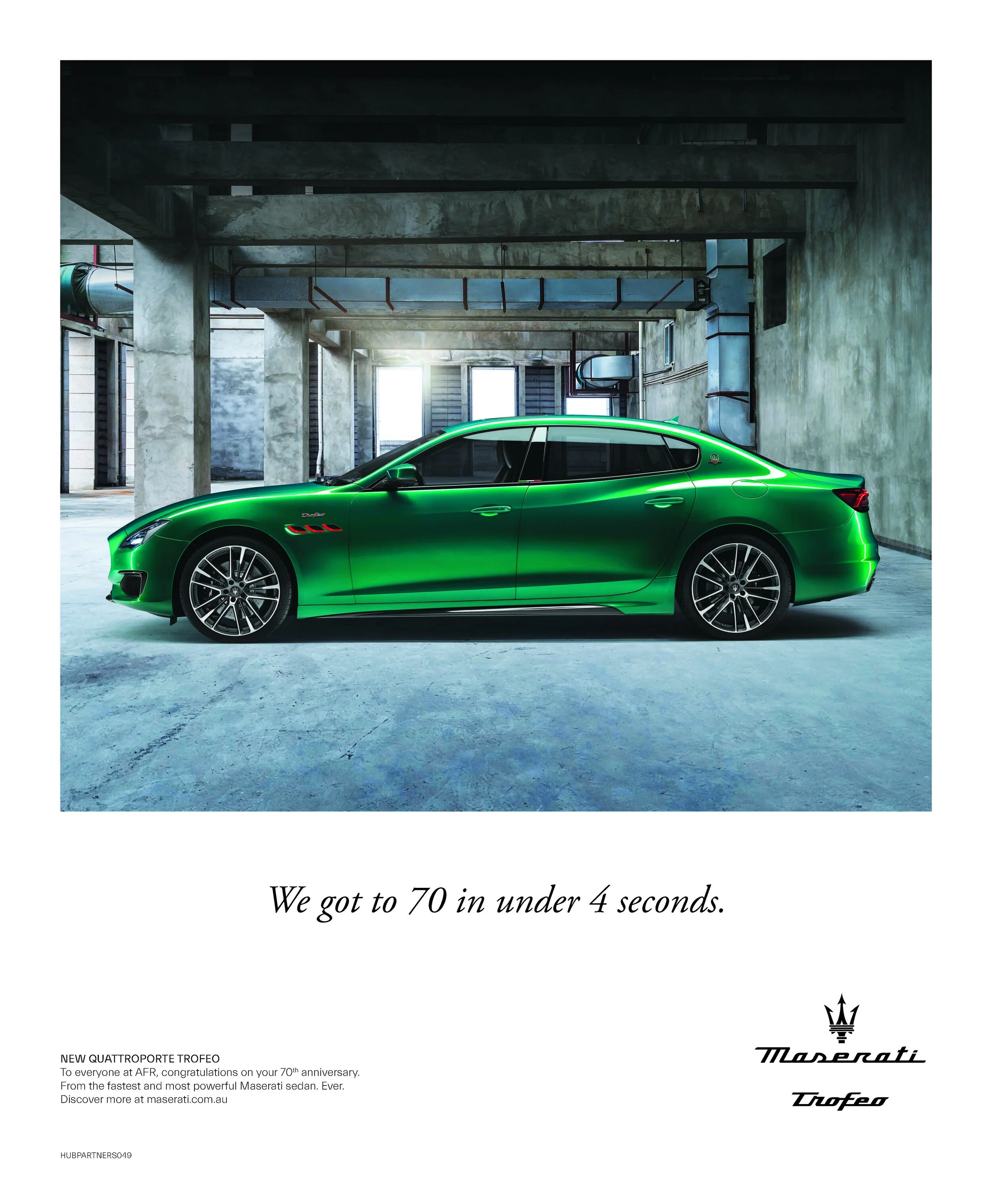 Green Maserati Quattroporte sedan parked in an industrial basement garage with concrete walls and ceiling.
