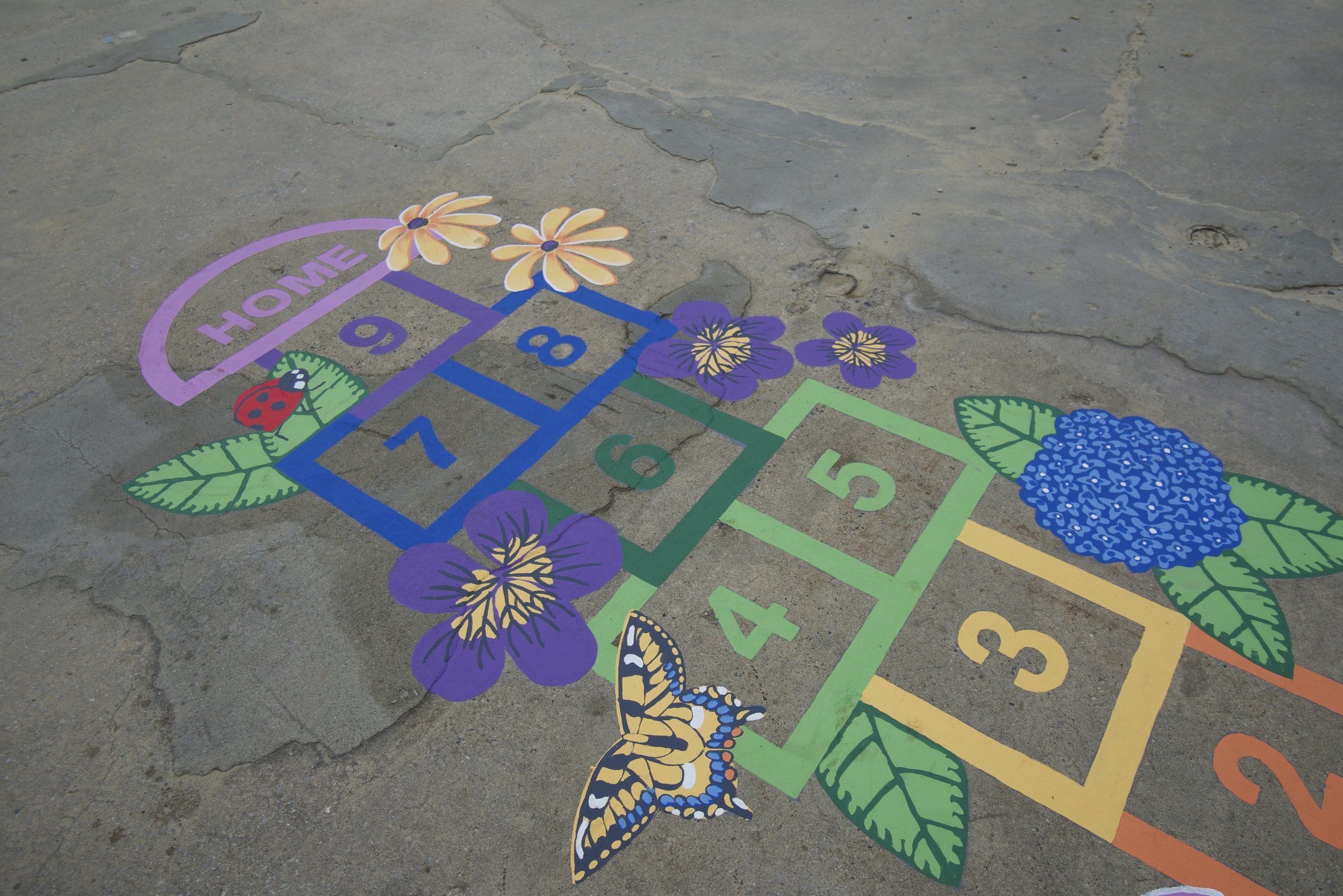 Beautiful painted colorful custom hopscotch with flowers and bright colors.