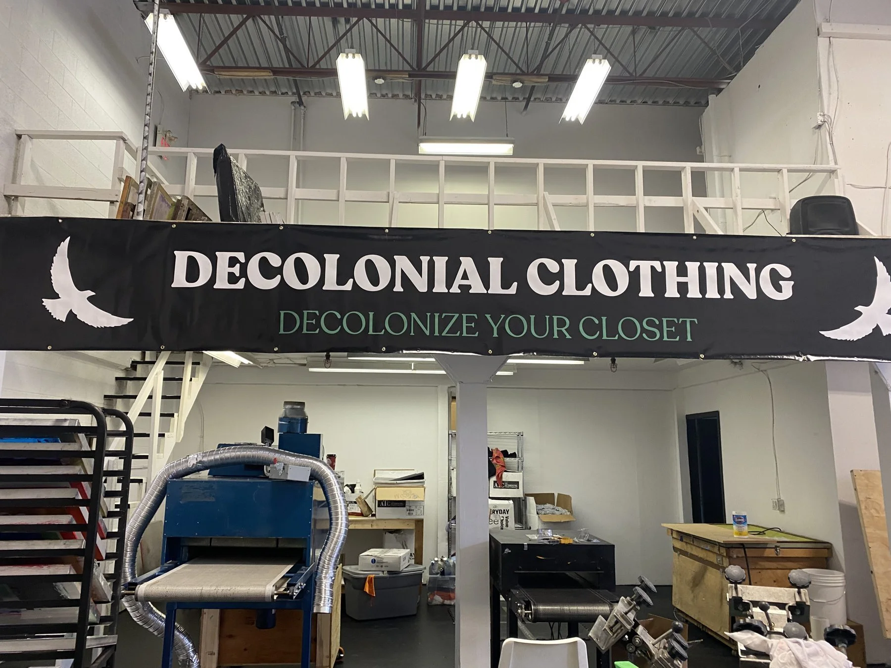 The Decolonial Clothing warehouse and print shop in Burnaby with its Decolonize Your Closet banner