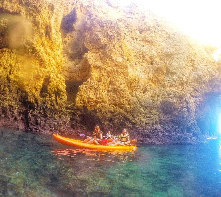 Crystal clear turquoise waters set against multicolored rocks.