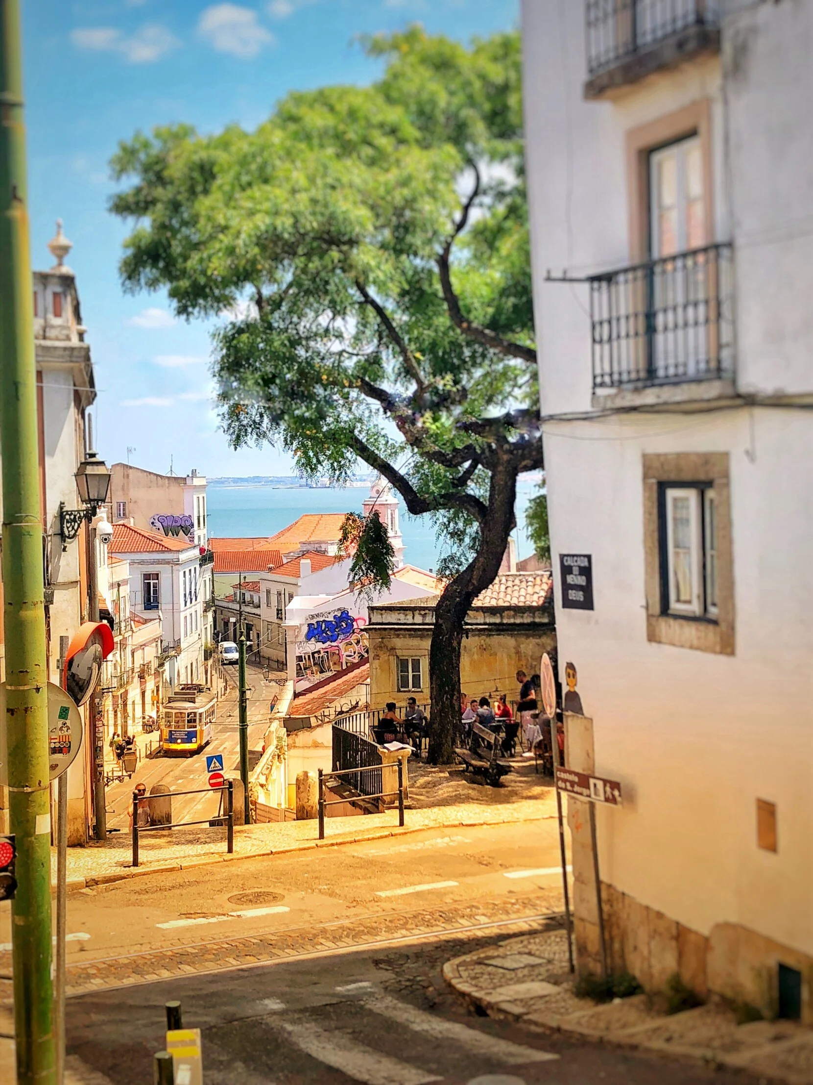 A view through the buildings of the famous Trolley 28 and the sea.