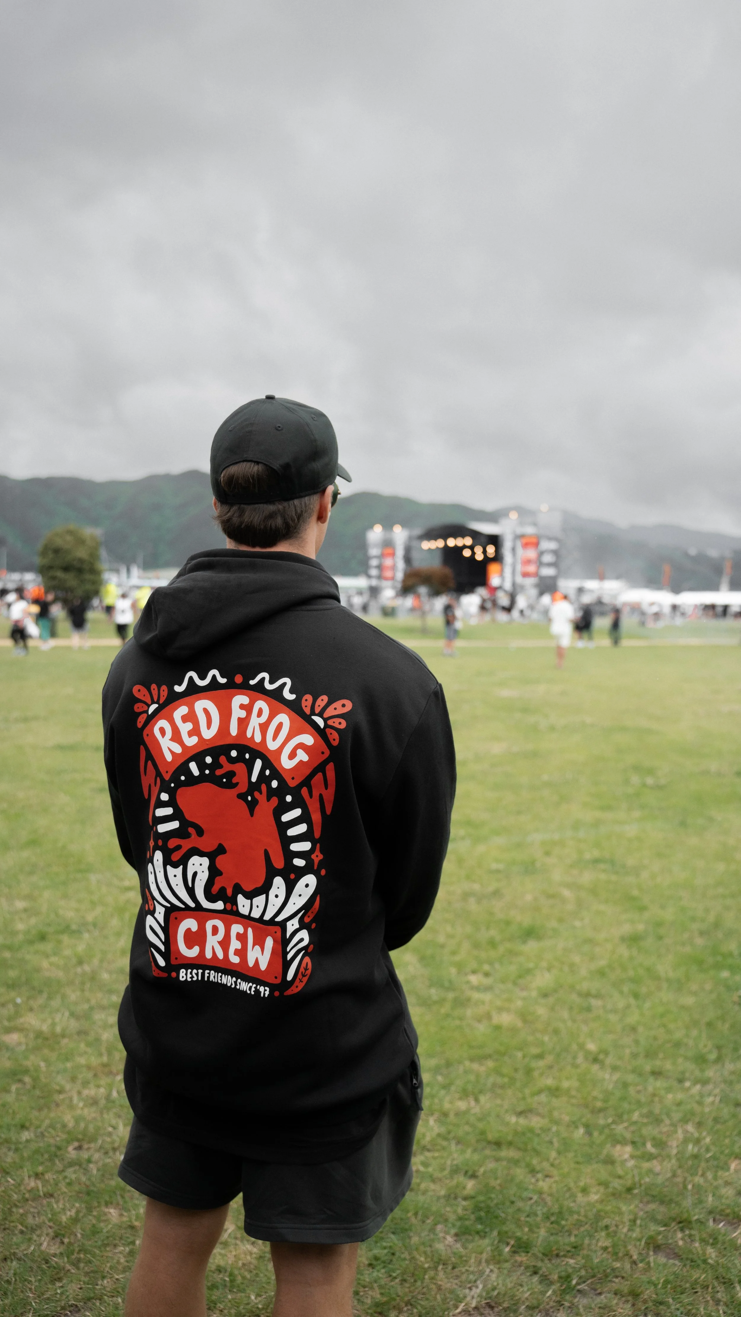 Person wearing Red Frog Crew hoodie at outdoor event