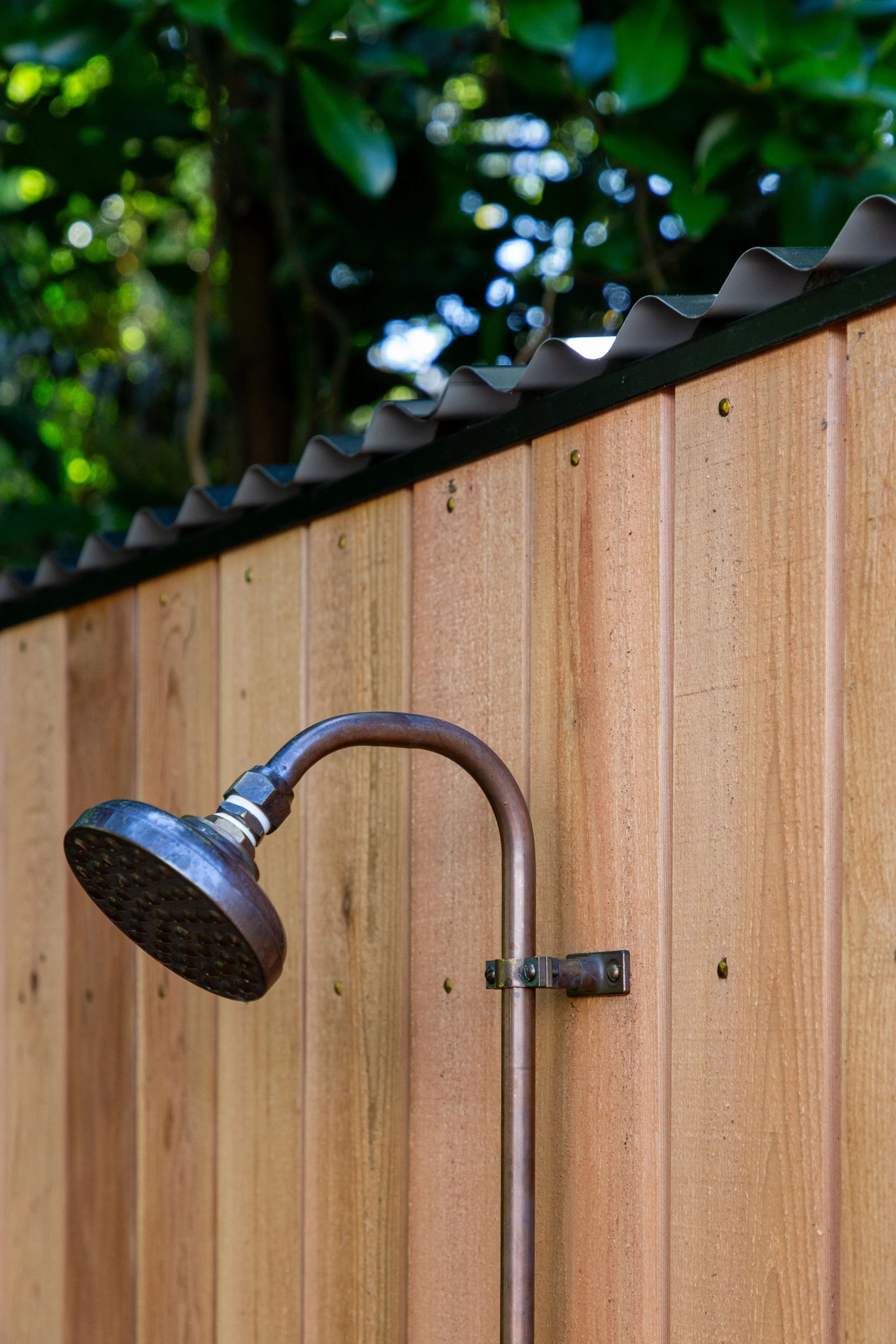 Cedar outdoor sauna with Copper Shower designed to elevate an Auckland garden retreat.