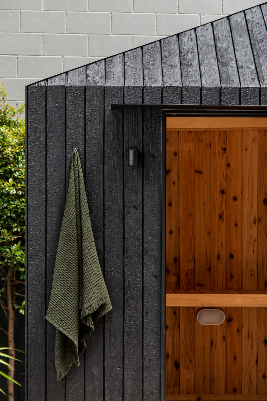 Charred Wood Sauna with Green Towel.png