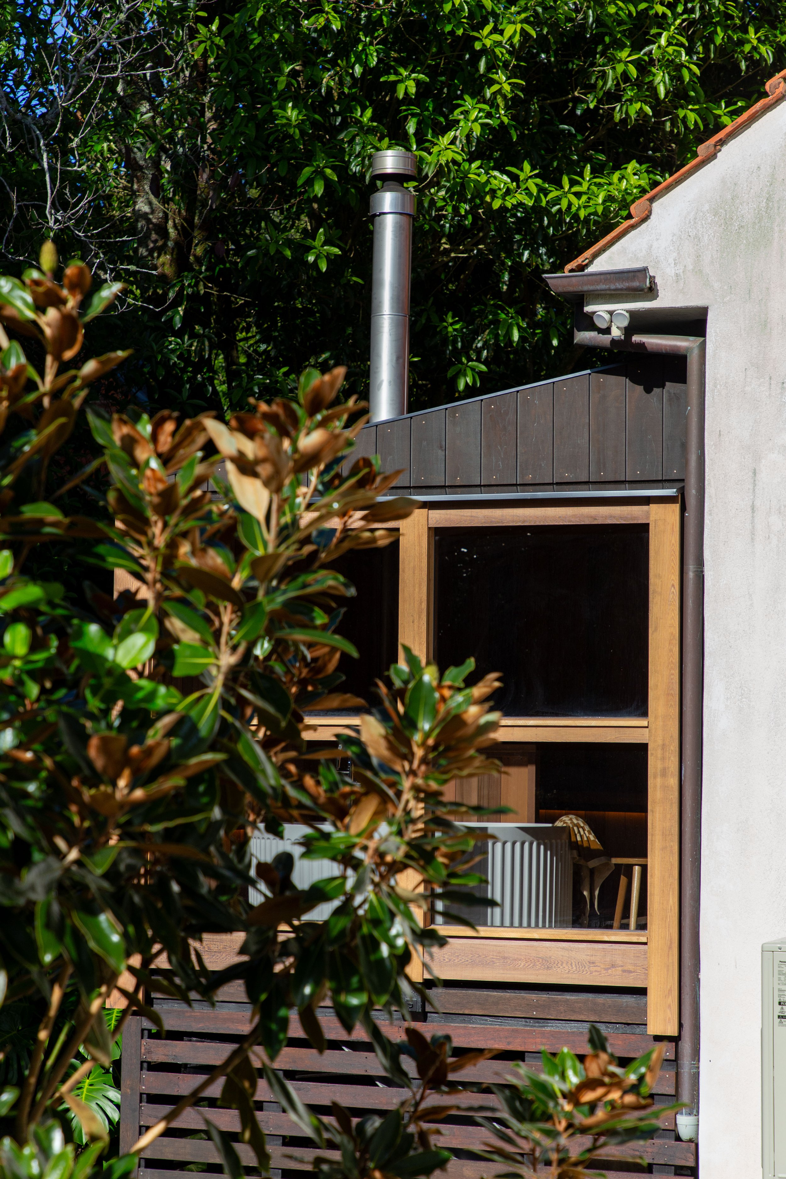 Exterior view of the custom sauna and bath house, custom designed and built within the existing lean-to of an old established house in Remuera, New Zealand.