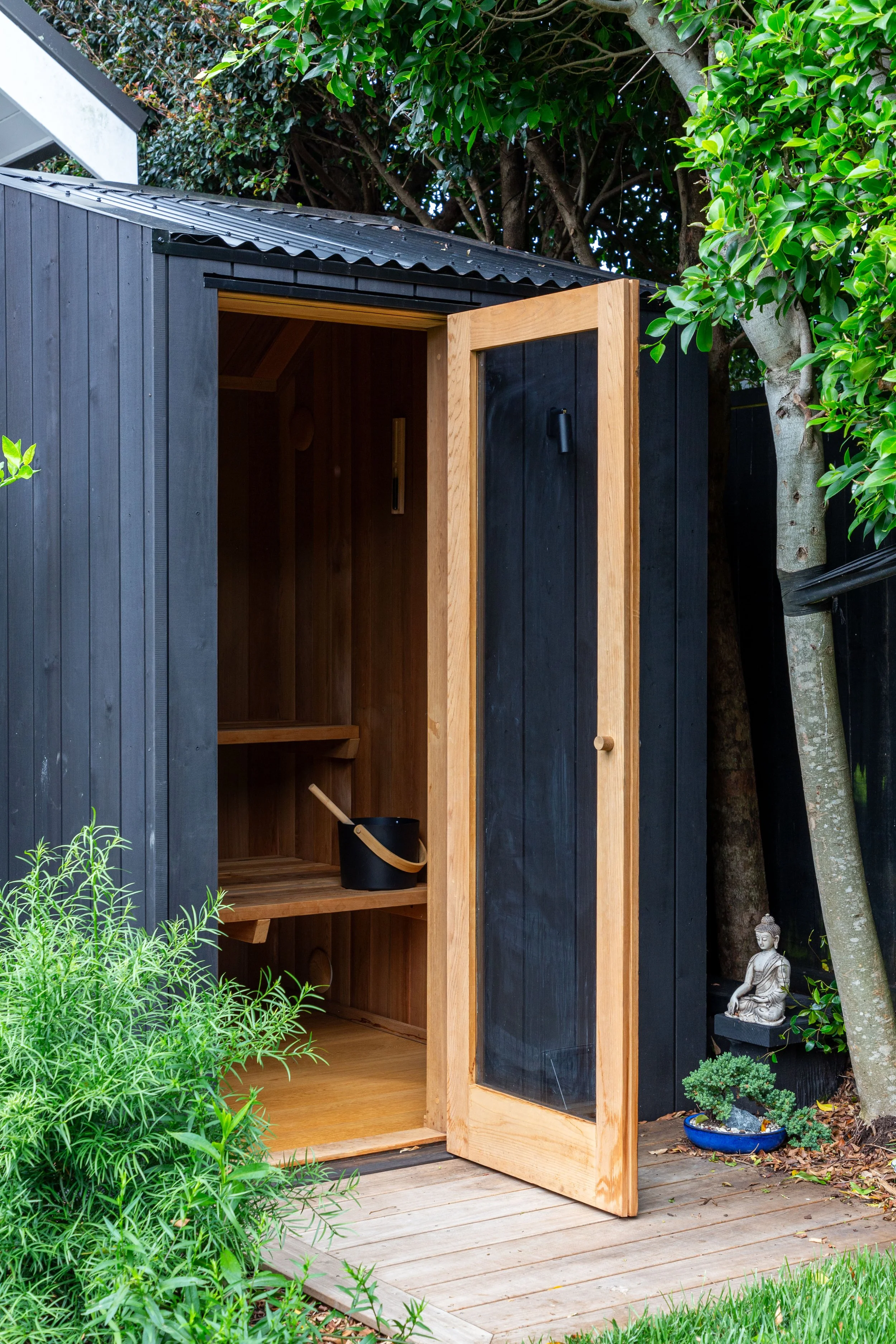 Outdoor garden sauna with solid timber door and natural cedar lining, custom designed and built by Hideaway