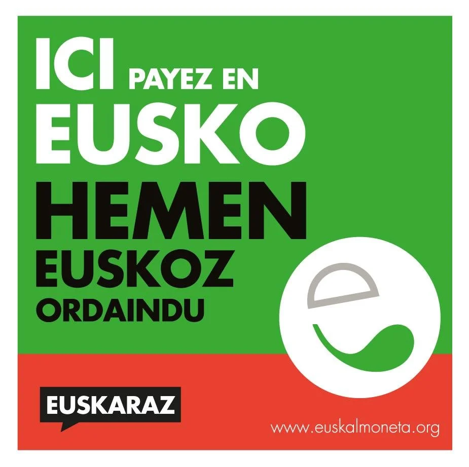 Affiche promotionnelle indiquant que les paiements en Eusko sont acceptés dans cet endroit, avec les textes en français et en basque, ainsi qu'un logo circulaire et l'adresse du site web euskalmoneta.org.