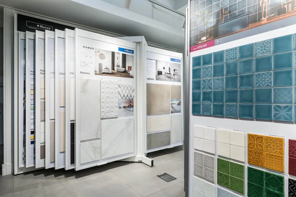Mostruário de azulejos de diferentes cores, texturas e padrões em uma loja de materiais de construção.