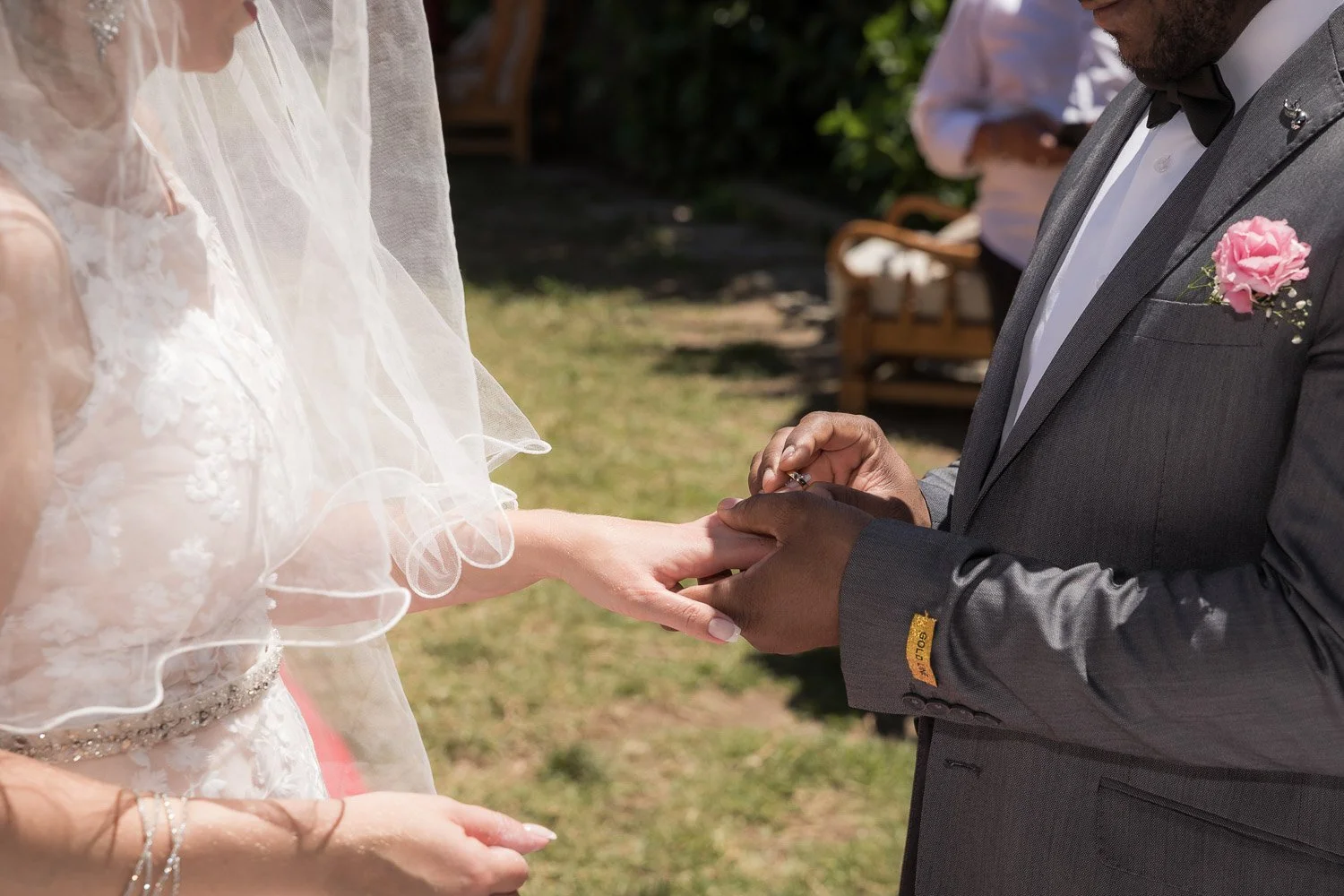 Casal trocando alianças de casamento ao ar livre.