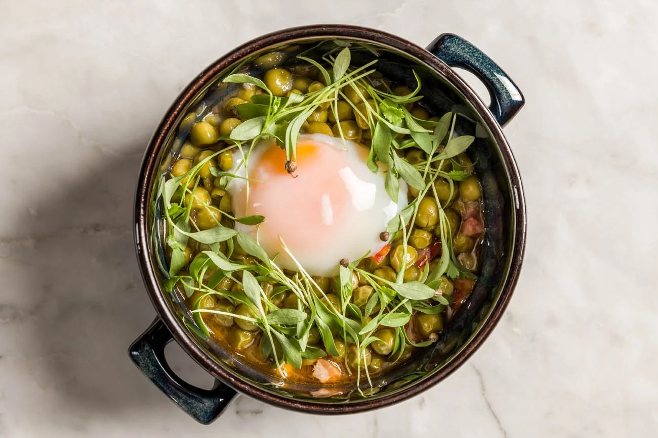 Marmita com ervilhas, ovo cozido e folhas verdes