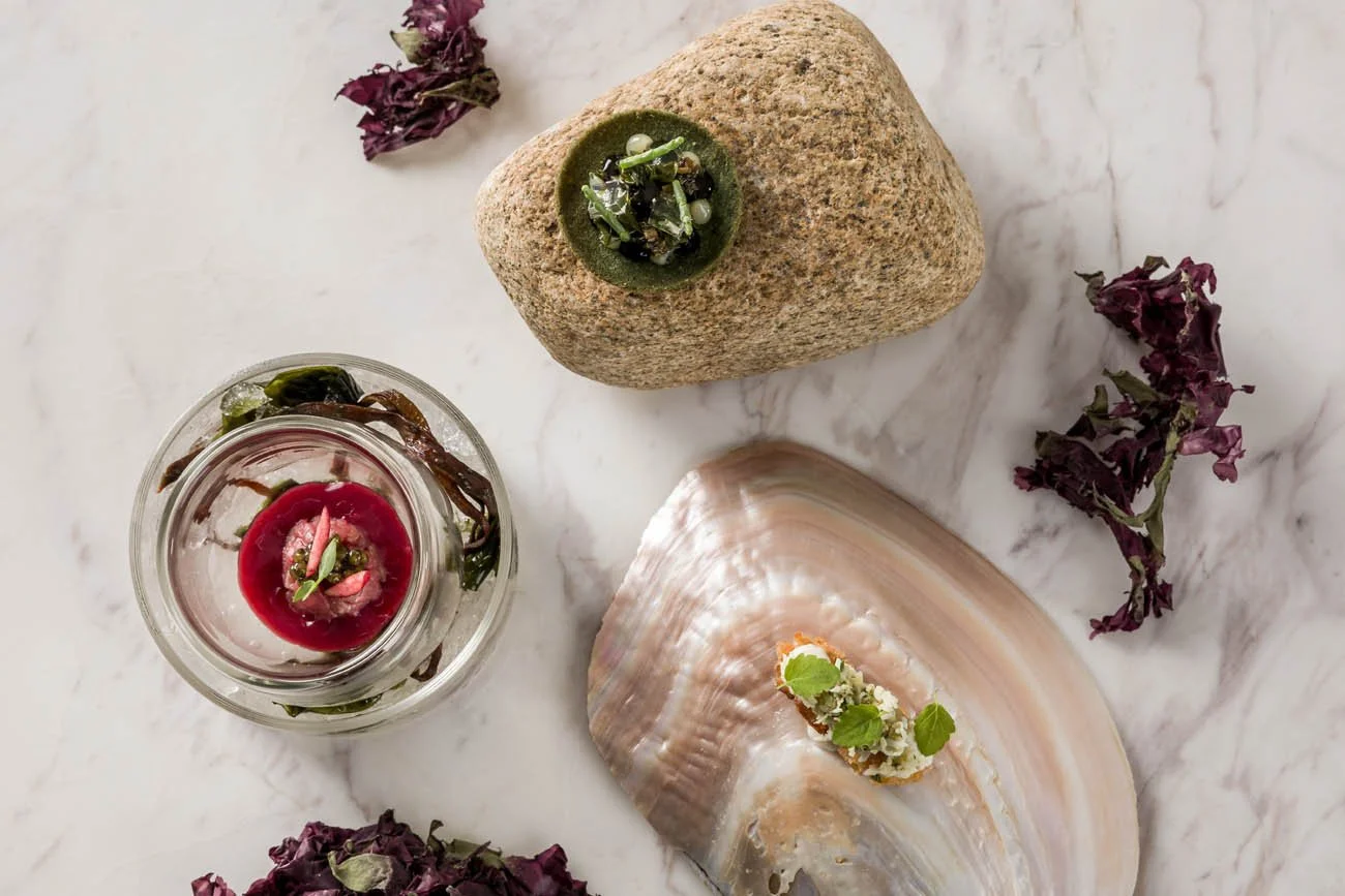 Peixes decorativos com plantas e flores secas sobre uma superfície de mármore