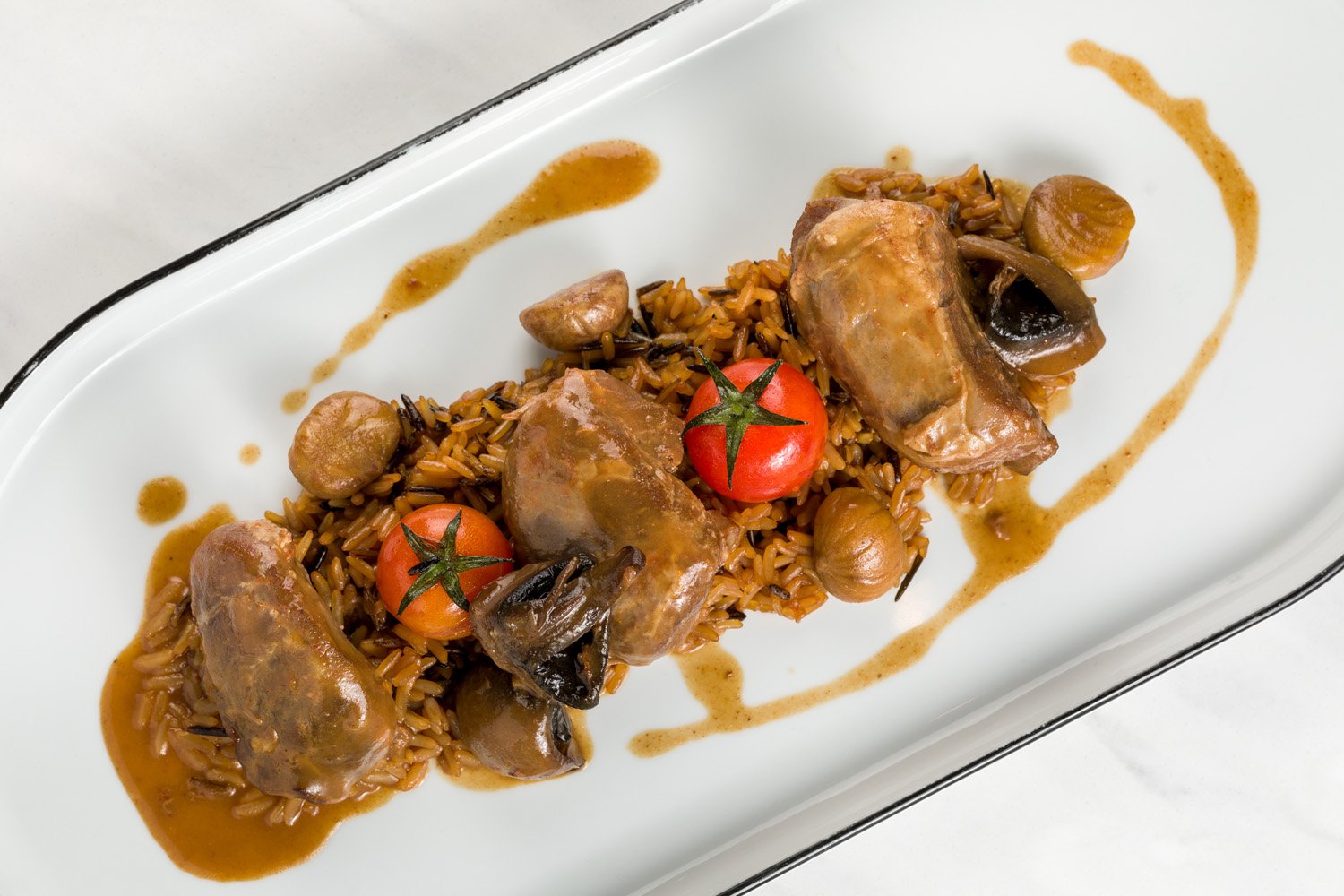 Prato de arroz com molho, ovos de codorna, tomate-cereja e cogumelos, decorado com molho de cor marrom claro.