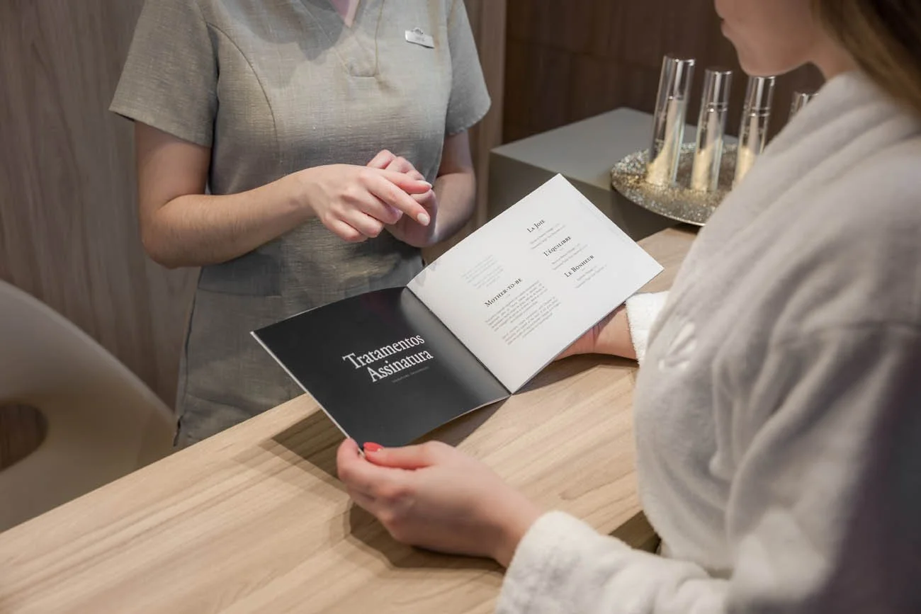 Pessoa apresentando assinatura no menu de um restaurante ou serviço de assinatura na recepção.