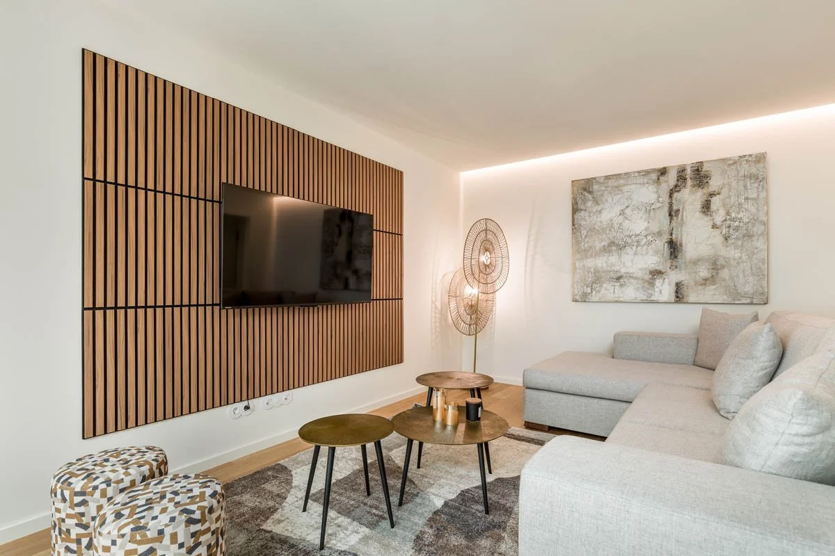 Sala de estar moderna com parede de madeira, televisão, sofá cinza, quadro abstrato na parede e luminária decorativa