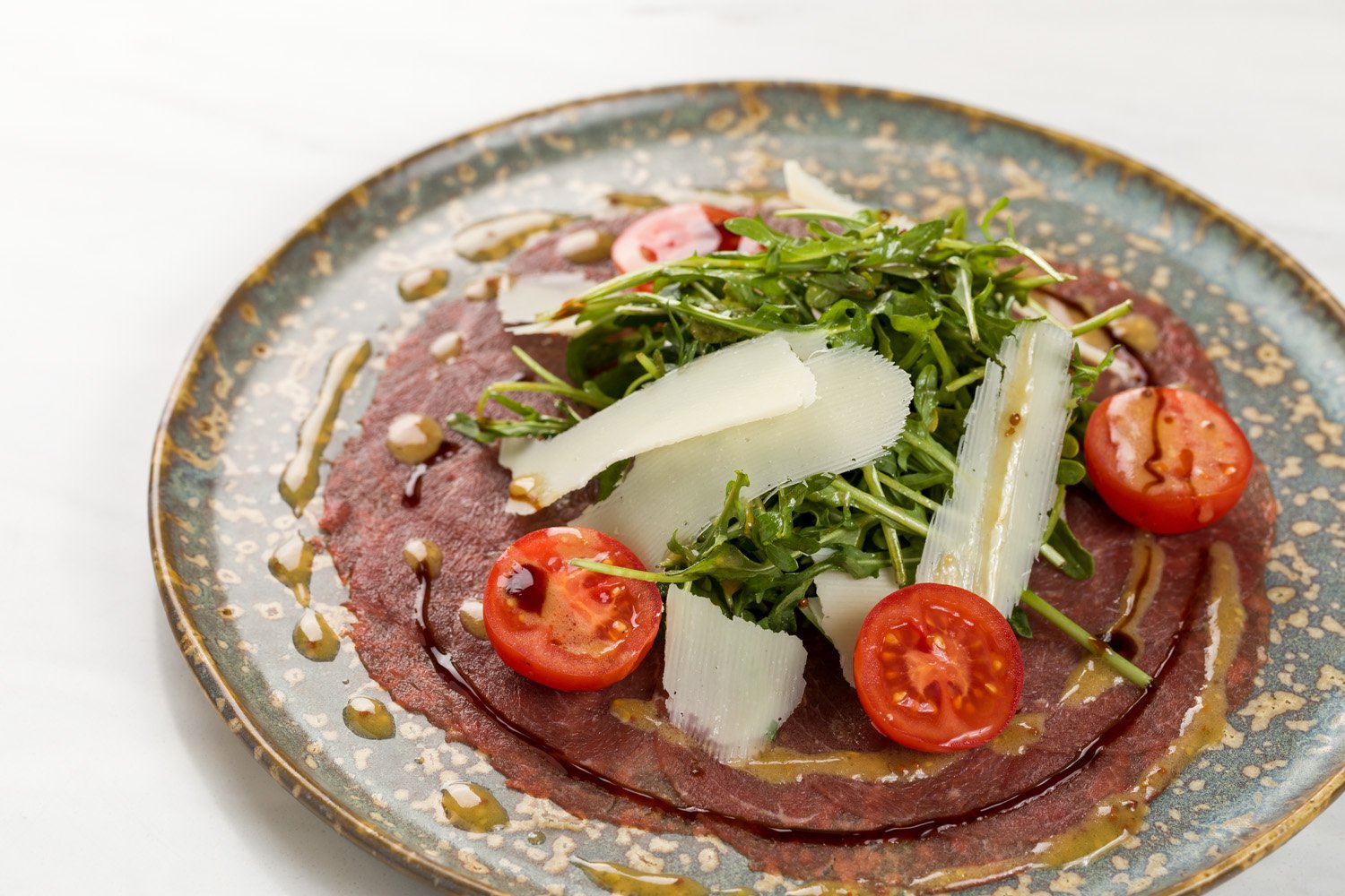 Salada de carne com tomate, alface e queijo em um prato decorativo