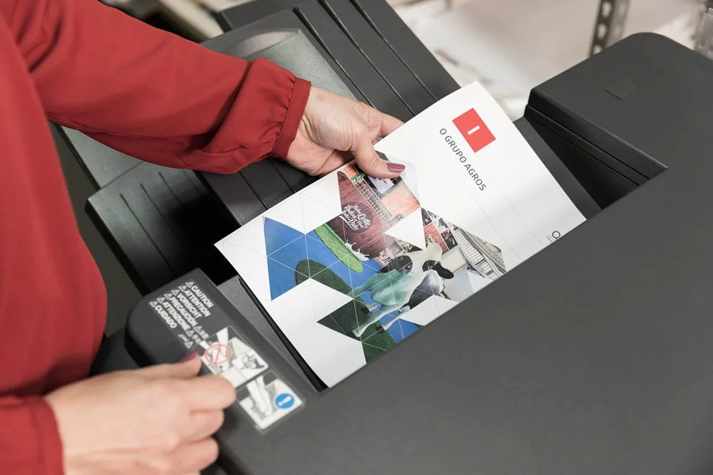 Pessoa colocando uma folha de papel na máquina de xerox