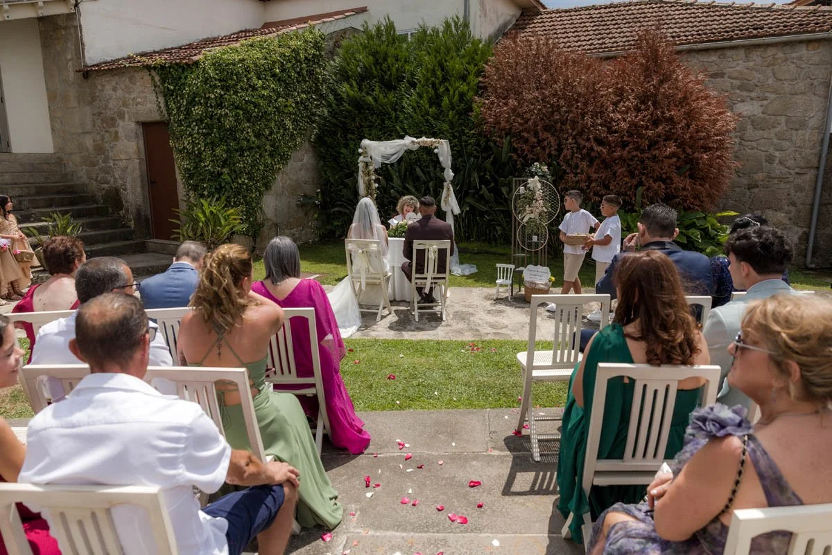 Casamento ao ar livre com noivos, testemunhas, convidados e crianças na cerimônia em um jardim