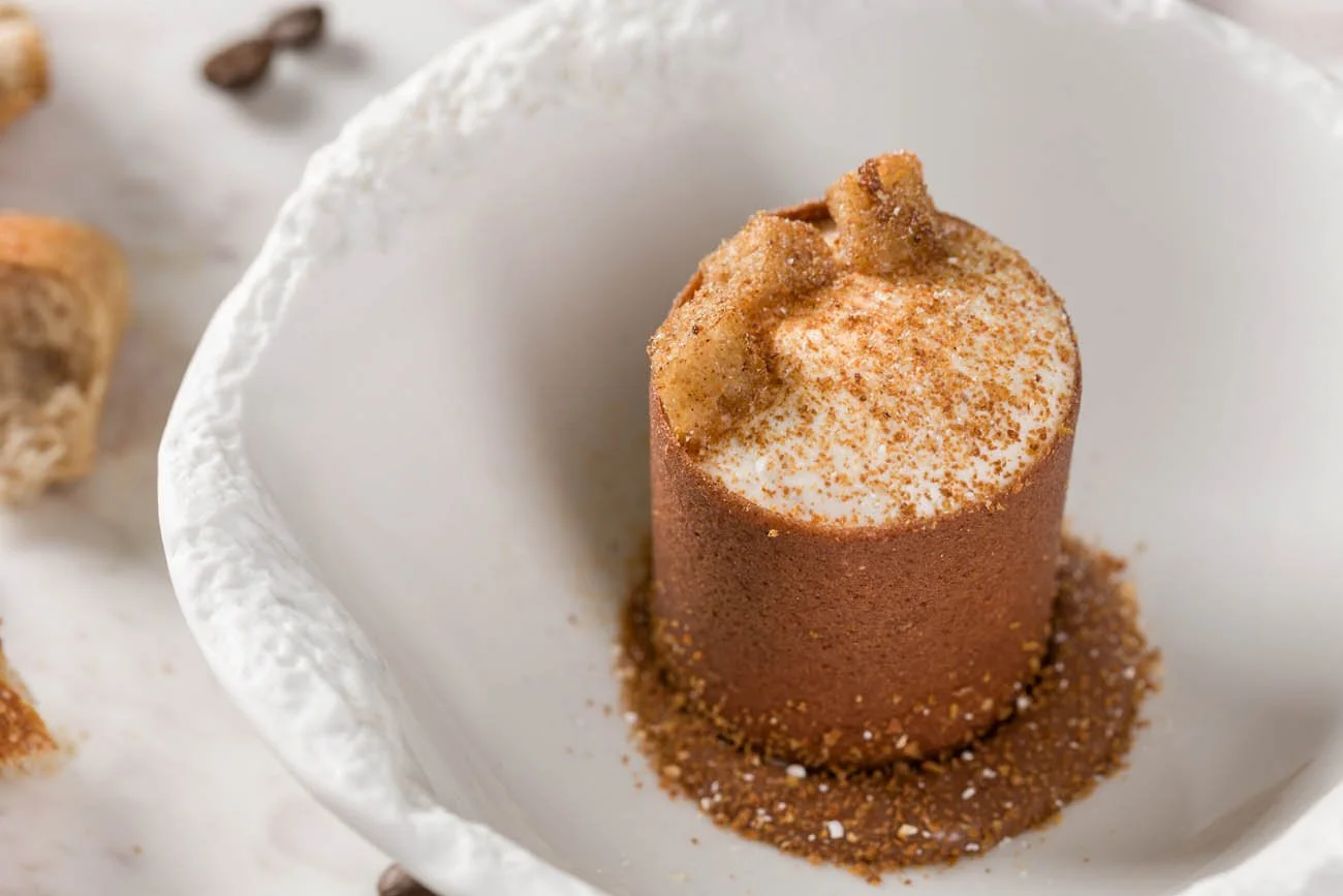 Sobremesa de sobremesa de chocolate com creme e biscoito no topo, servida em uma tigela branca