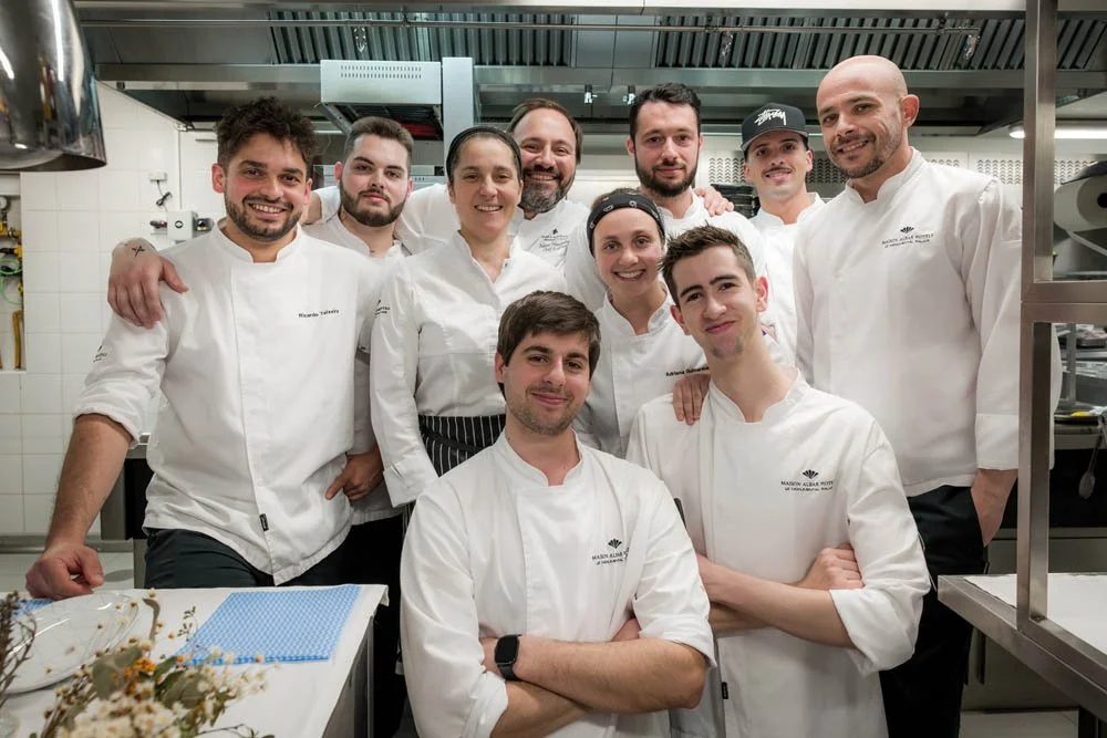 Equipe de chefs de cozinha em uma cozinha profissional, sorrindo e posando para a foto.