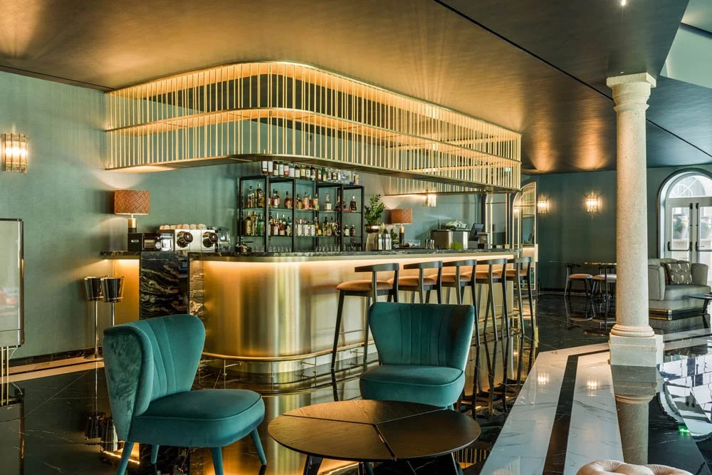 Bar sofisticado com cadeira azul, iluminação ambiente e decoração moderna