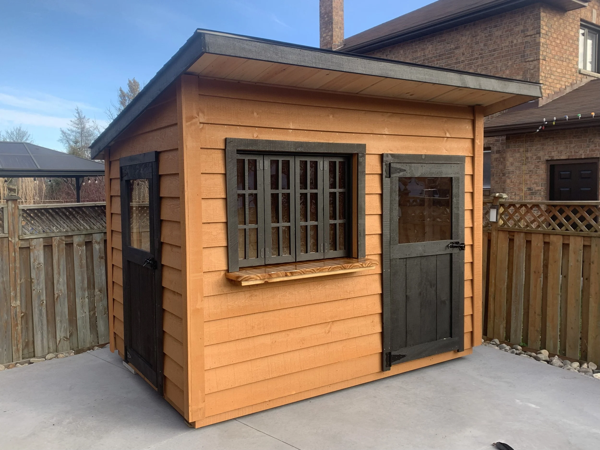 Shed:   
6x10 Lean-To (82" Eave) $3524  
 Options:   
2'x10' Overhang $616  
4' Cedar Bar with Windows $ 840 
Custom Stain $195 
2 x Custom Doors $350 
 Total: $5525