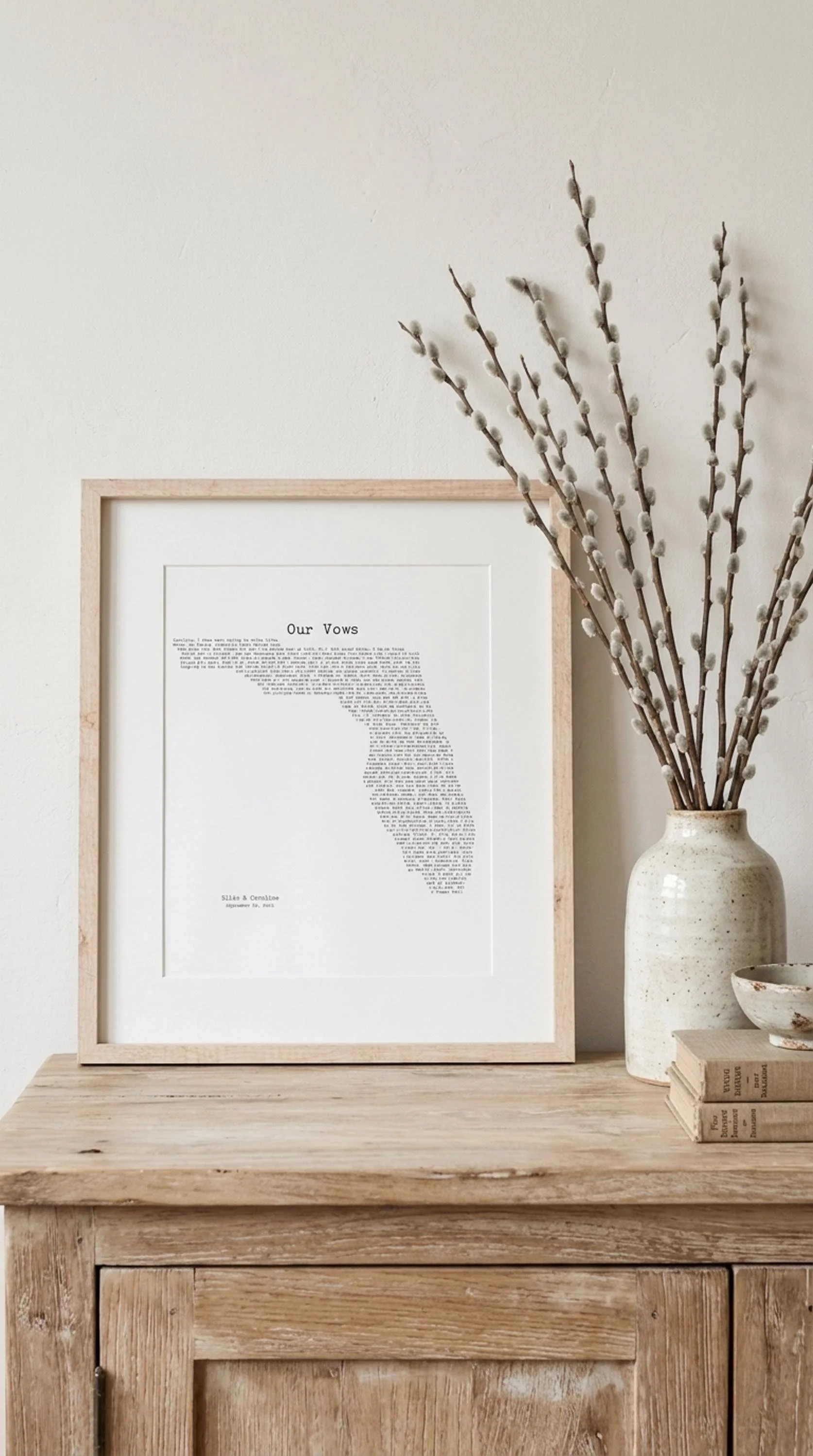 Close view of a framed Florida wedding vows print on a wood console with willow branches
