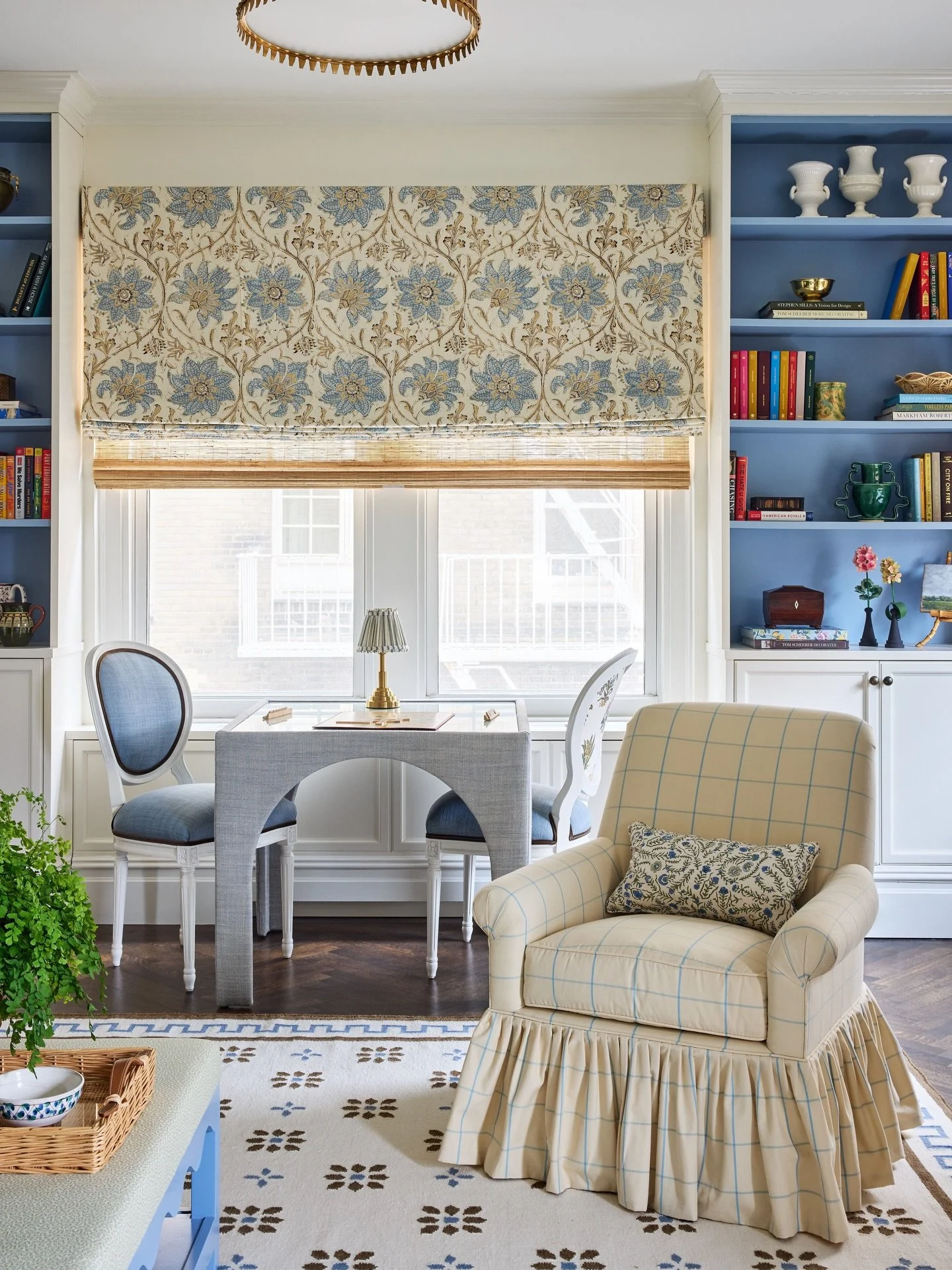 Cutie slice of this city living room designed for a young professional. The card table can serve multiple functions &mdash; games, drinks, work. I love the skirted swivel chair and shade of blue we painted the interiors of the bookcases.
📷 @kirstenr