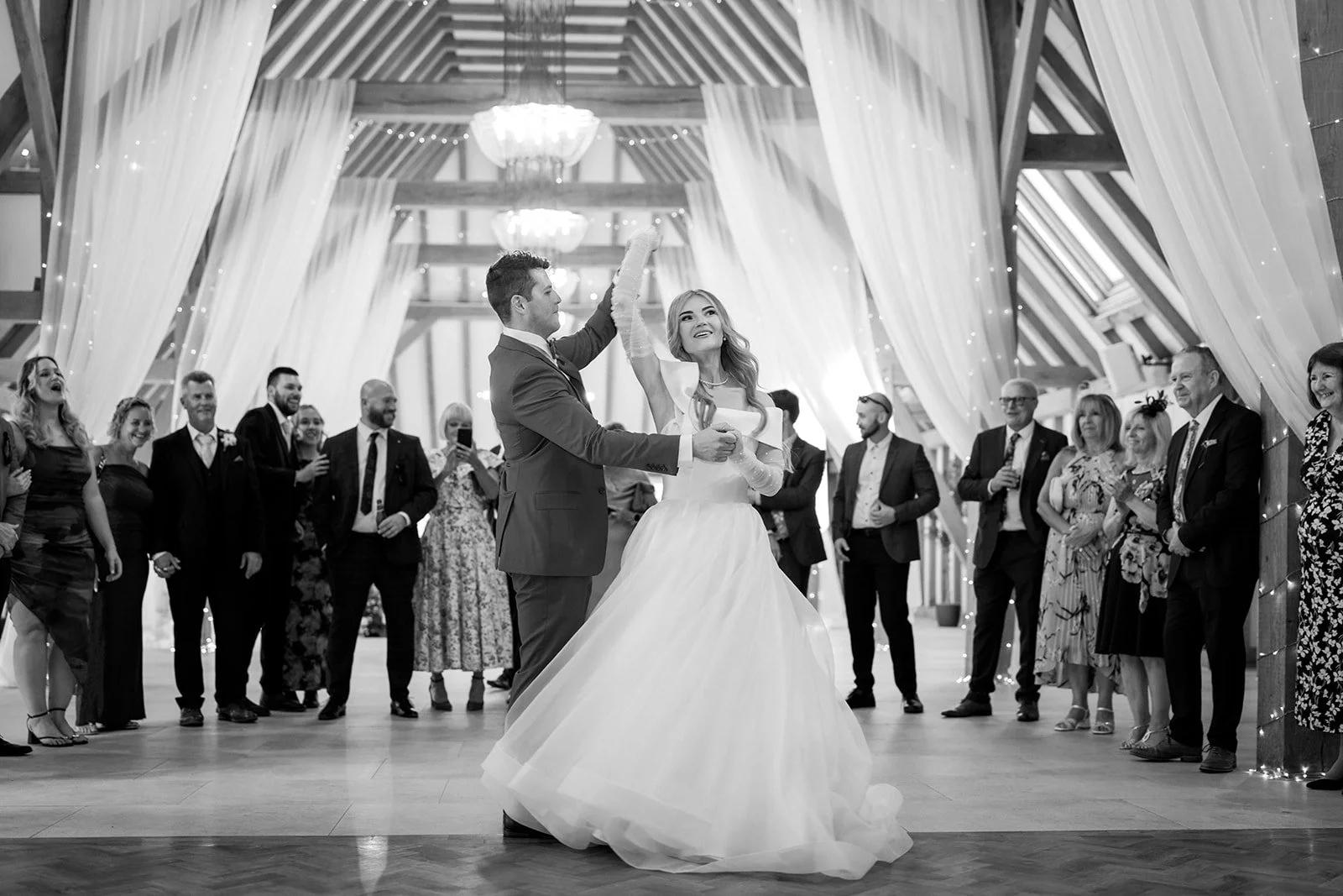 A couple enjoy their first dance as a married couple at The Old Kent Barn, Dover with their loved ones