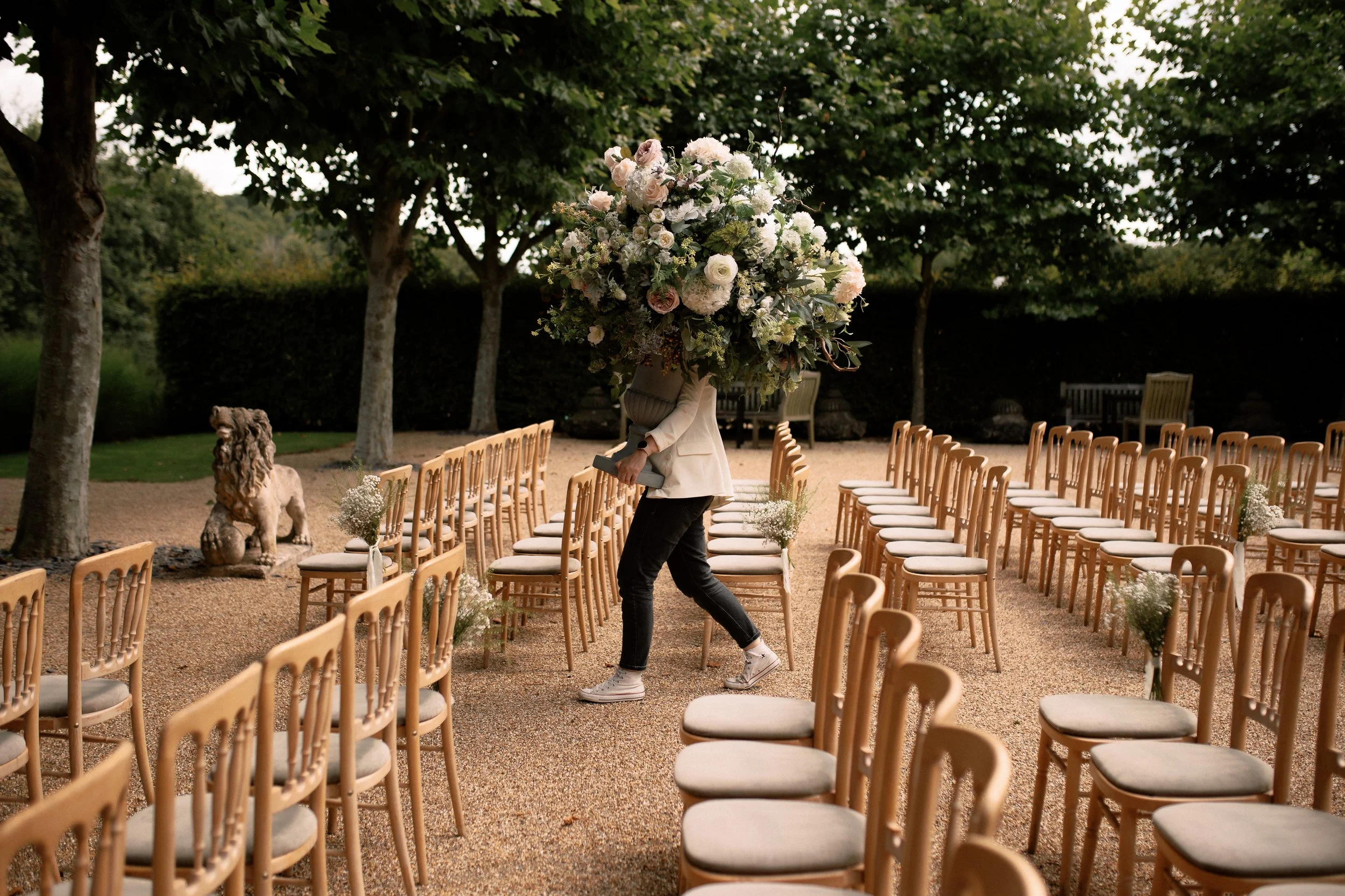 Florist carries a flower arrangement to the front of a wedding venue