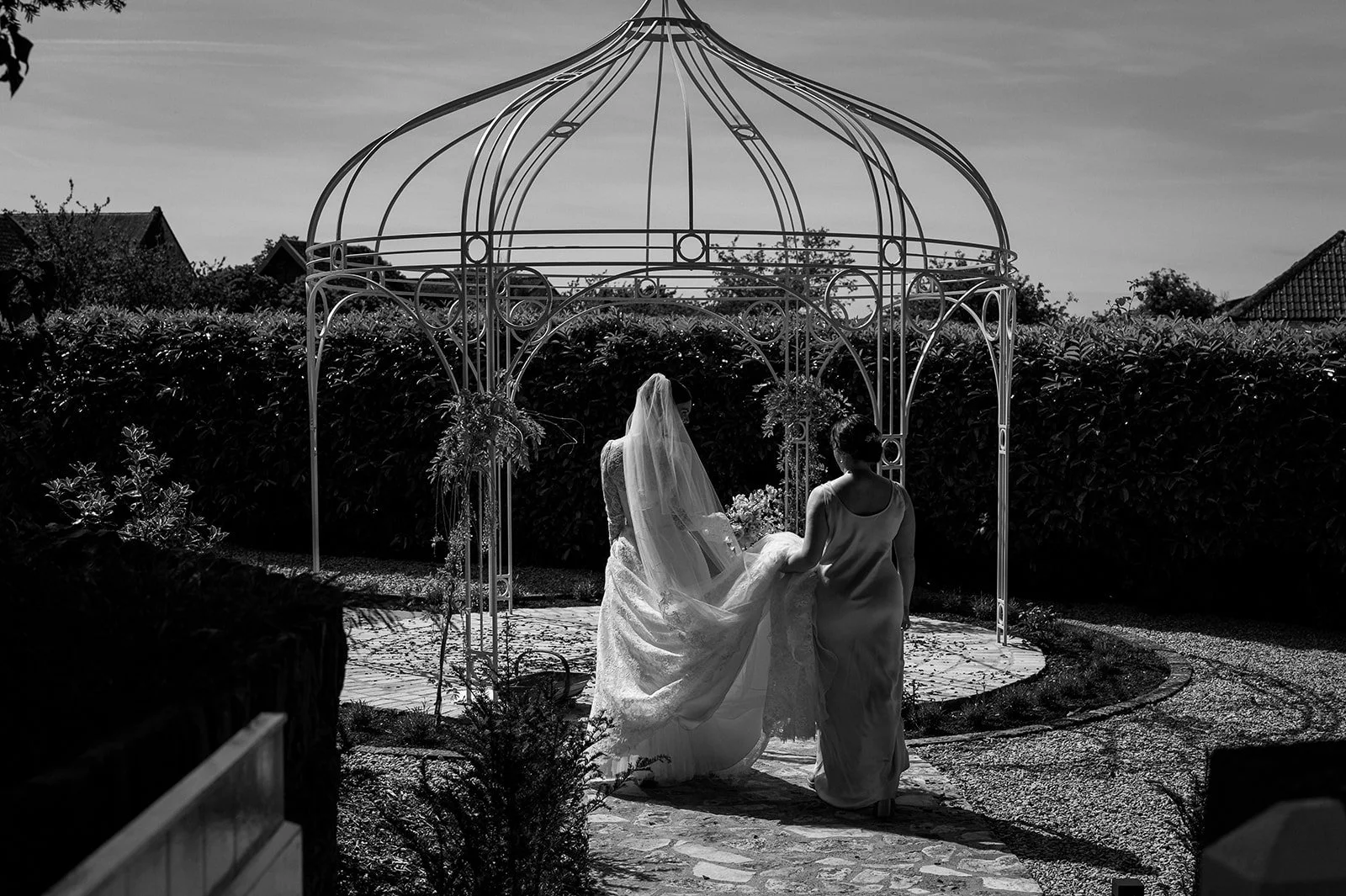 A bridesmaid helps the bride carry her dress on the way to the church on her wedding day