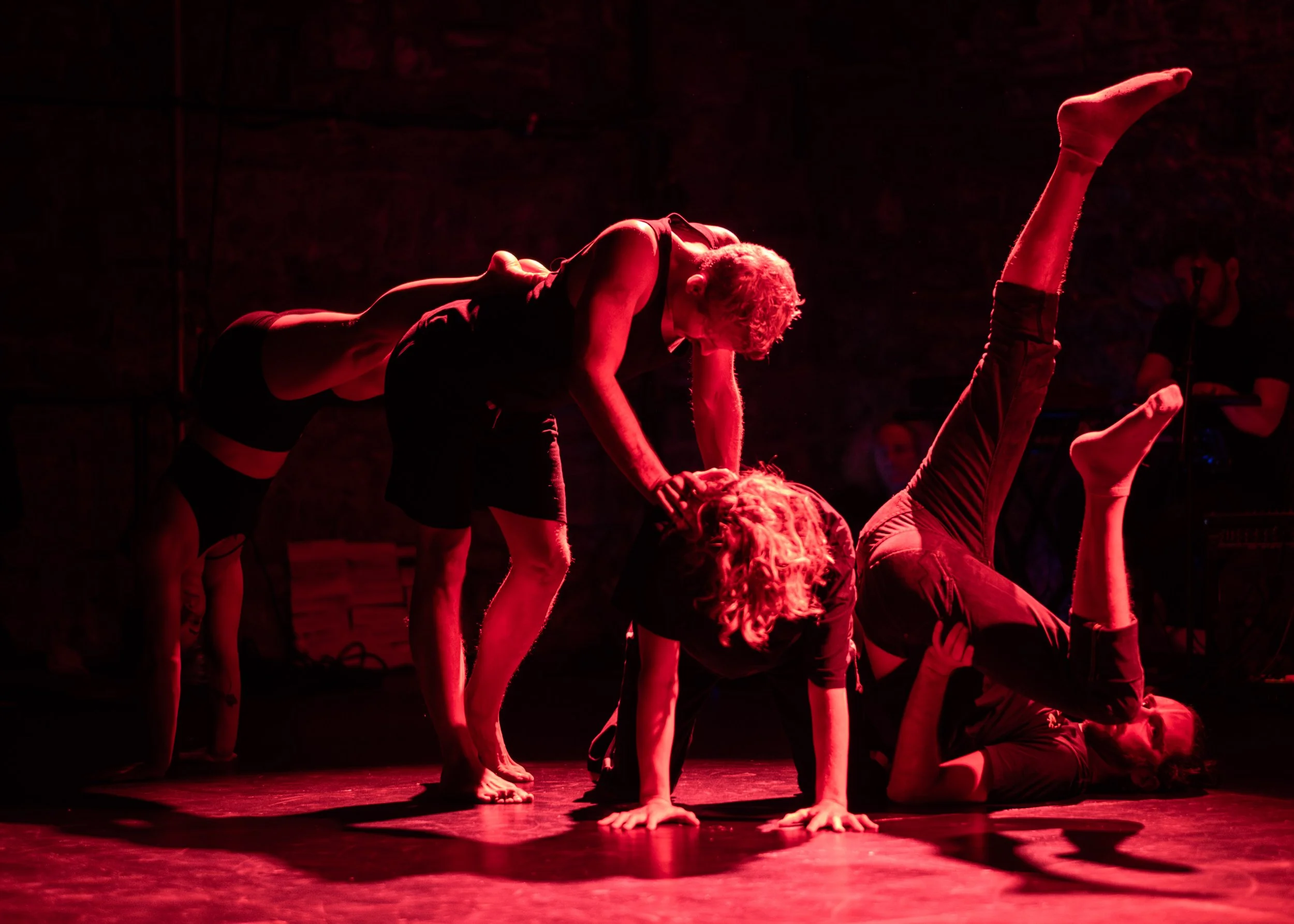 acrobatic performers in red lighting