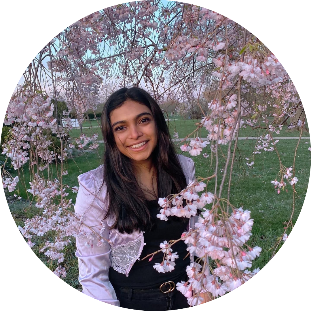 Rhea Thomas smiling amidst some cherry blossoms