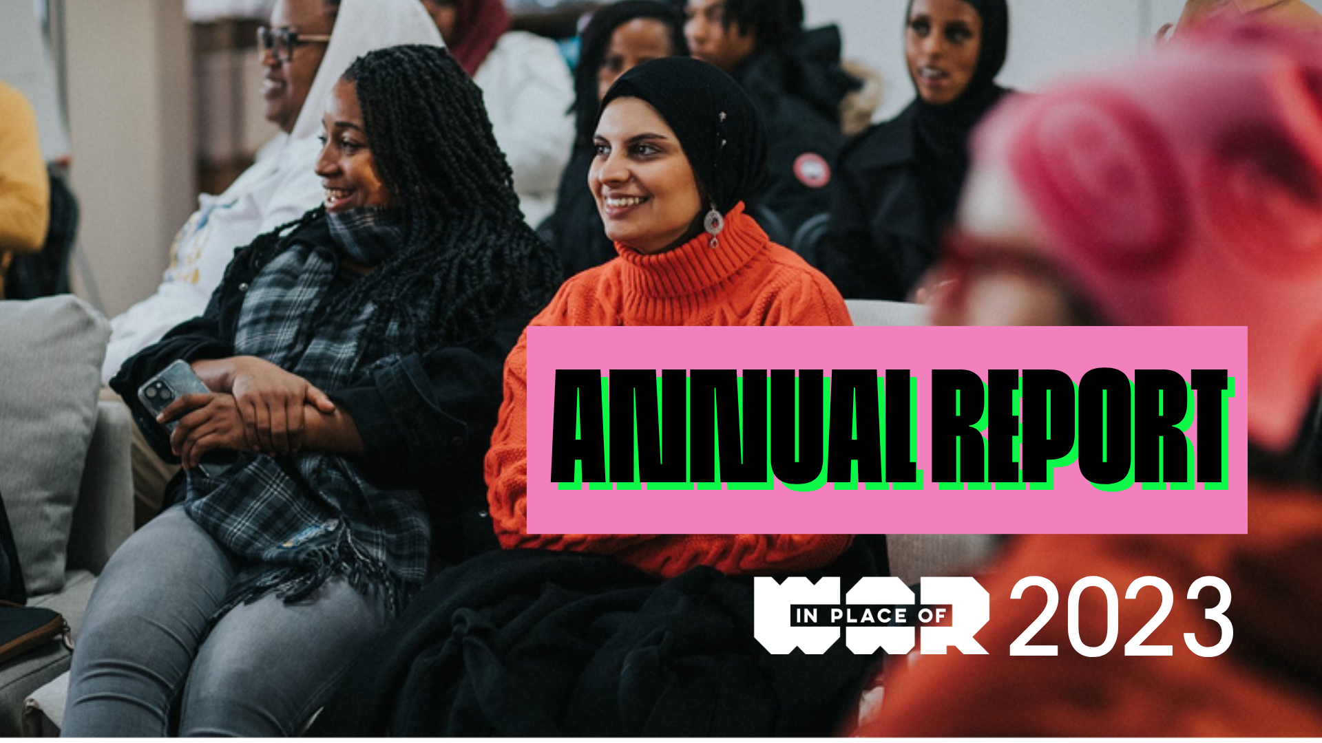 An image of two young women sat smiling in a crowd. Text reads: Annual Report, 2023, with the In Place of War logo.