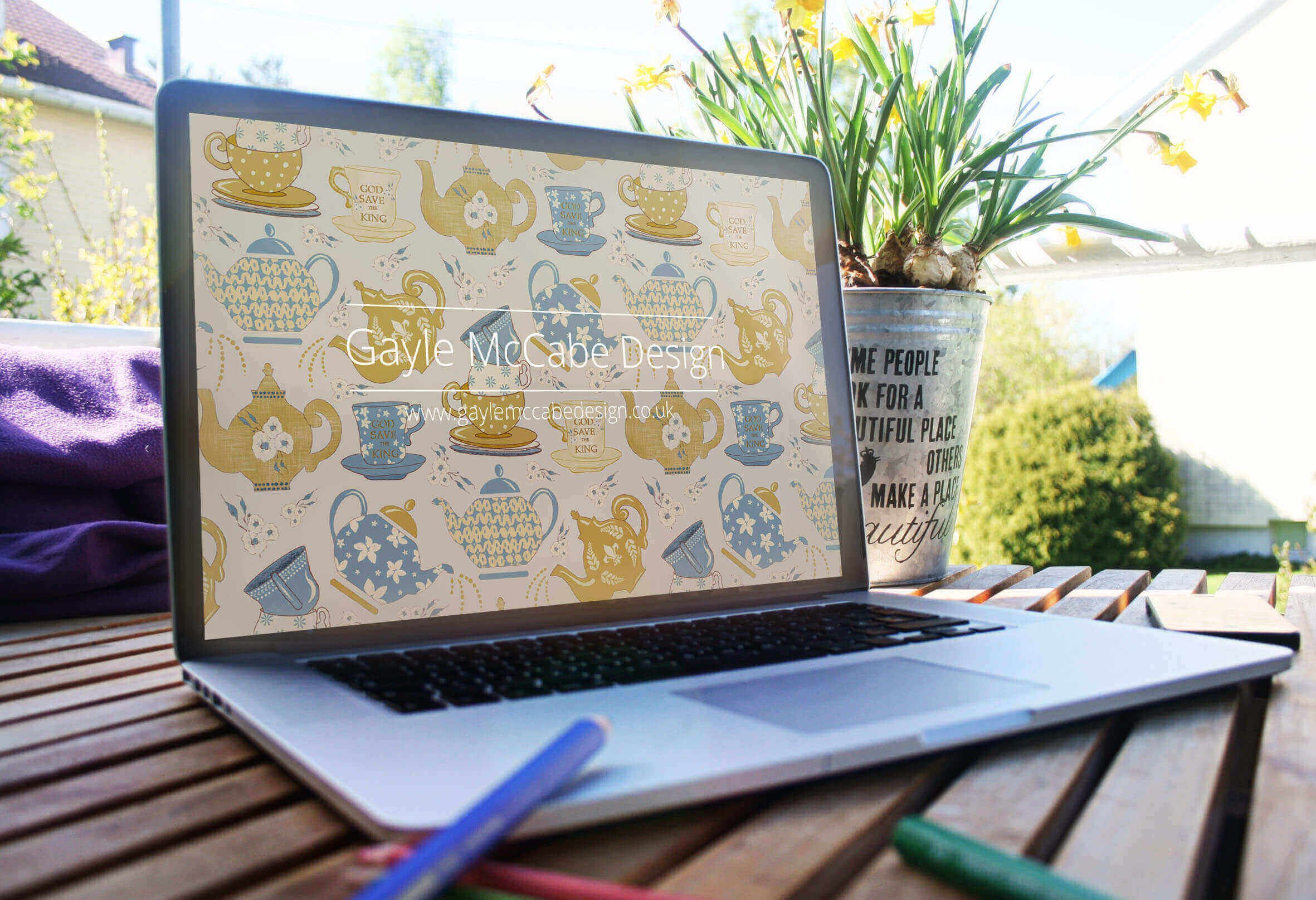 Laptop on outside table showing a teapot pattern by Gayle McCabe Design