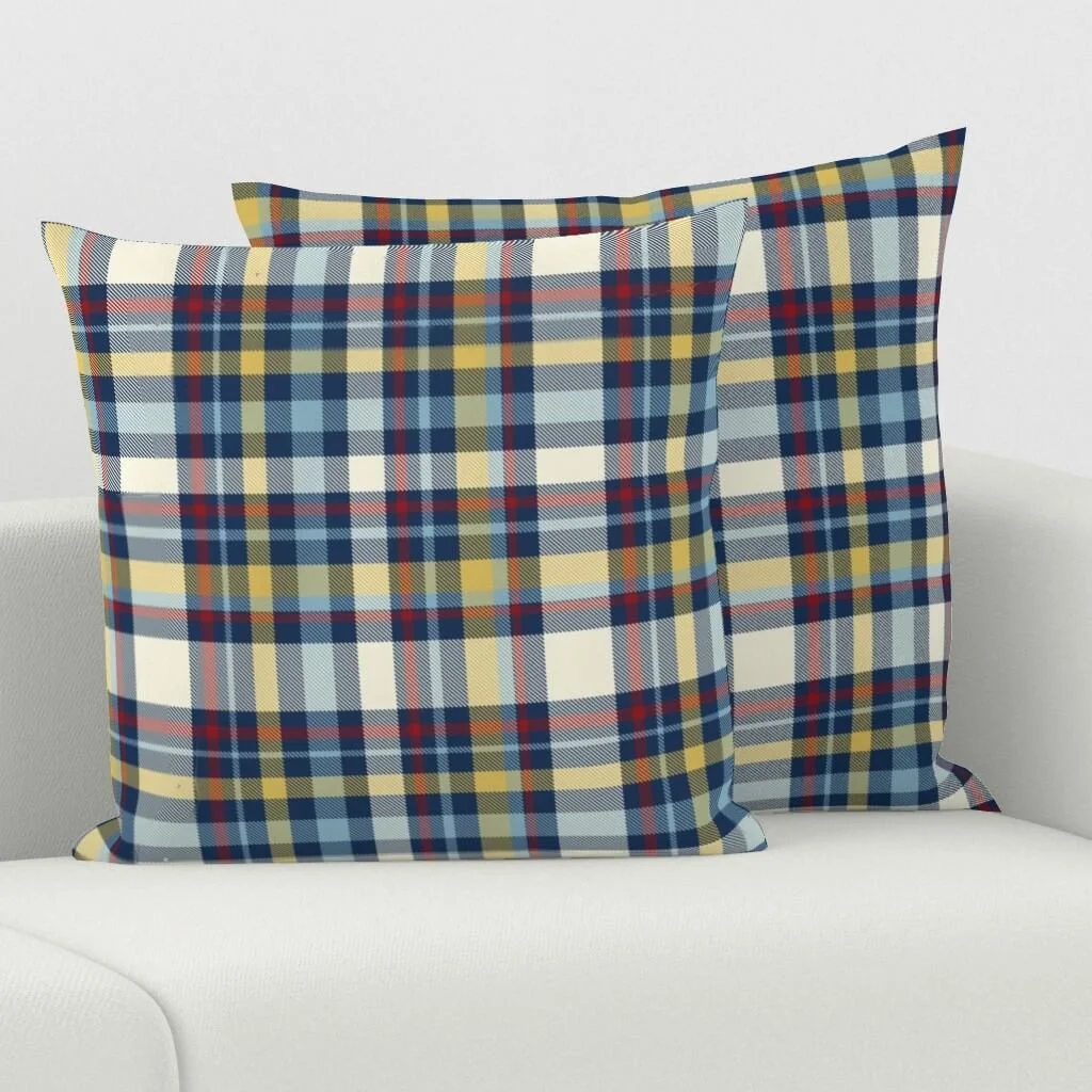 Two plaid-patterned decorative pillows on a white sofa.
