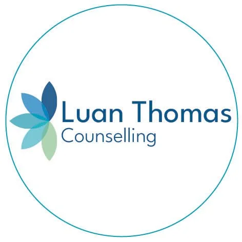 Luan Thomas Counselling logo with a stylized flower made of blue and green petals.