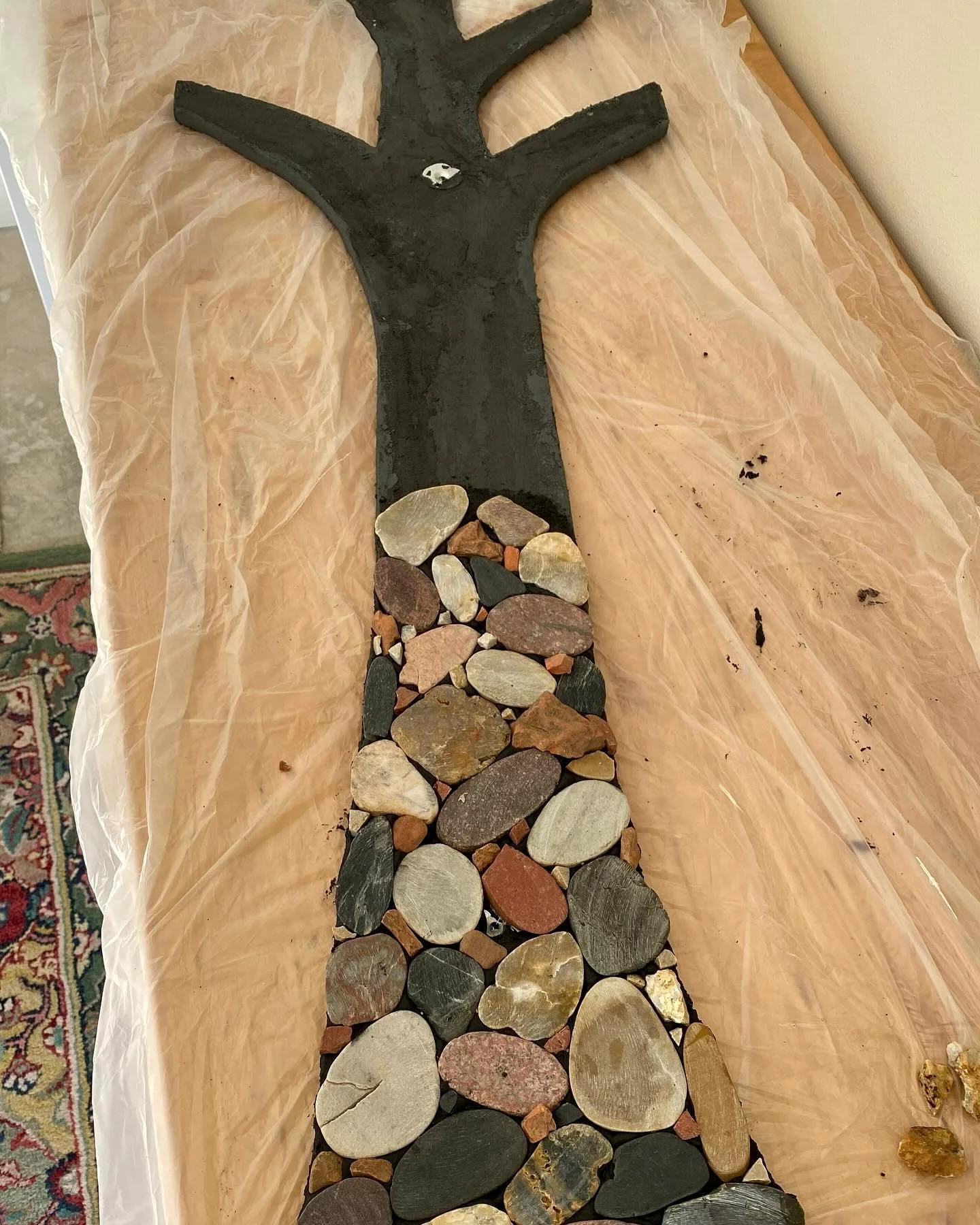 Working on a four-foot tree trunk, combining leftover stone tiles and rocks indigenous to the area. The red stones I collected on the Grand Ridge Trail and are a byproduct of the coal mine that once existed. The mosaic will be on this trail. 

#stone