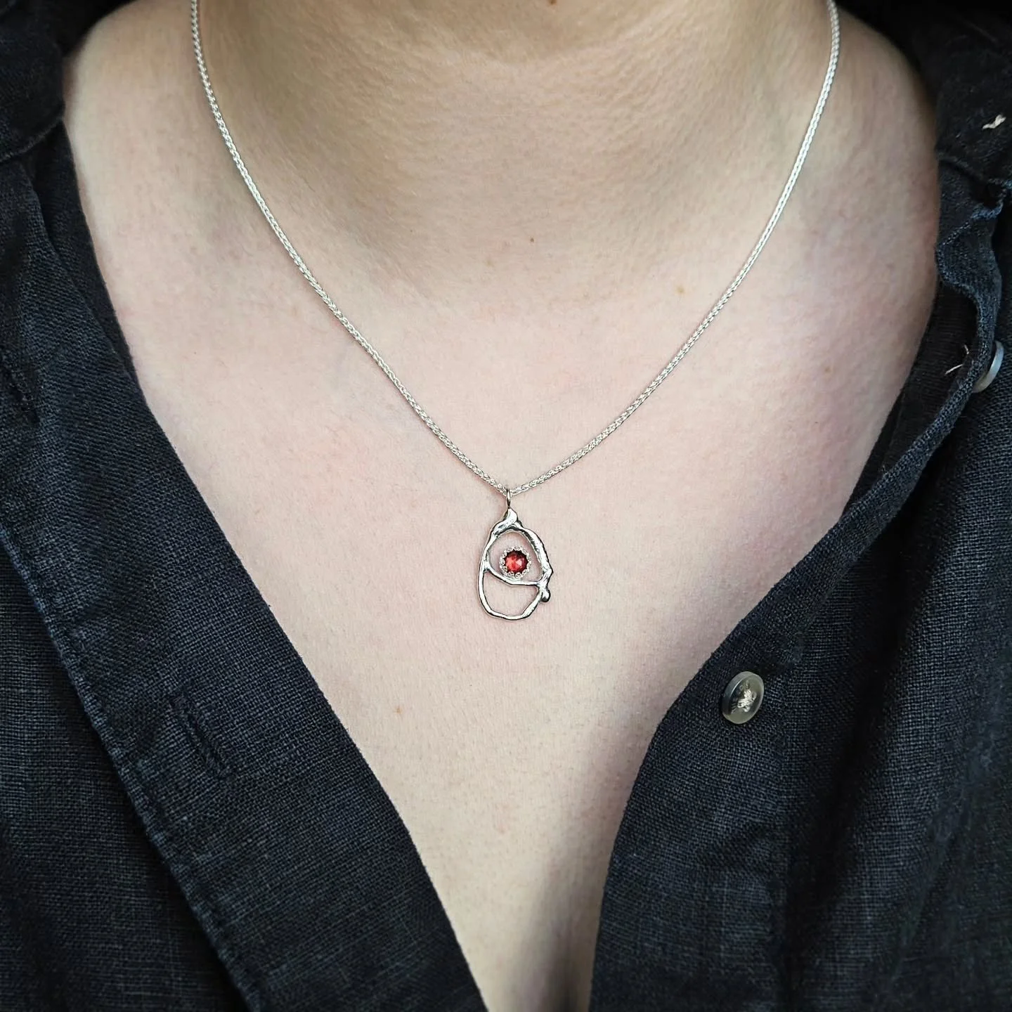 Handmade in my Northern Ireland studio, each Molten Necklace is carefully crafted using recycled sterling silver.
This design features a beautiful rose cut Garnet stone nestled in the centre.
As a fire element stone, Garnets are celebrated as powerfu