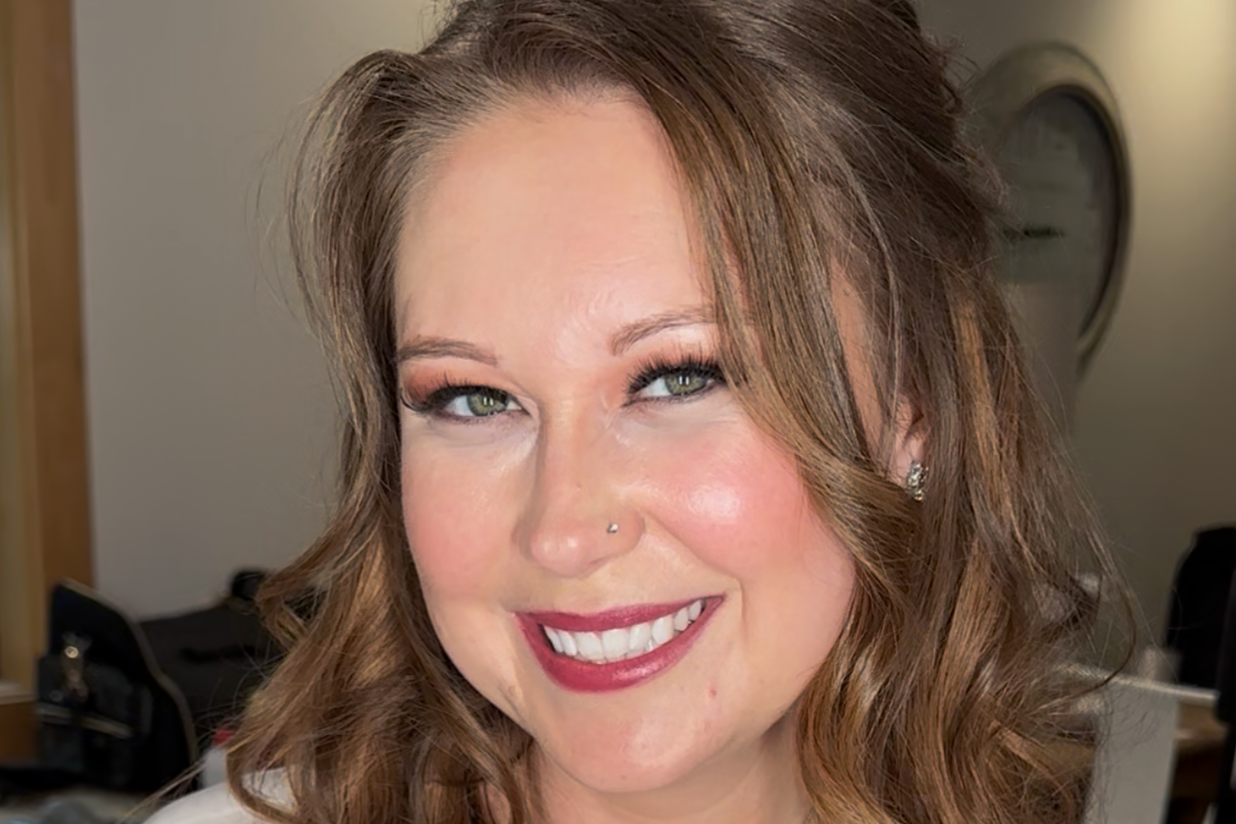 Close-up of a woman with blue eyes, makeup, and a wedding veil.