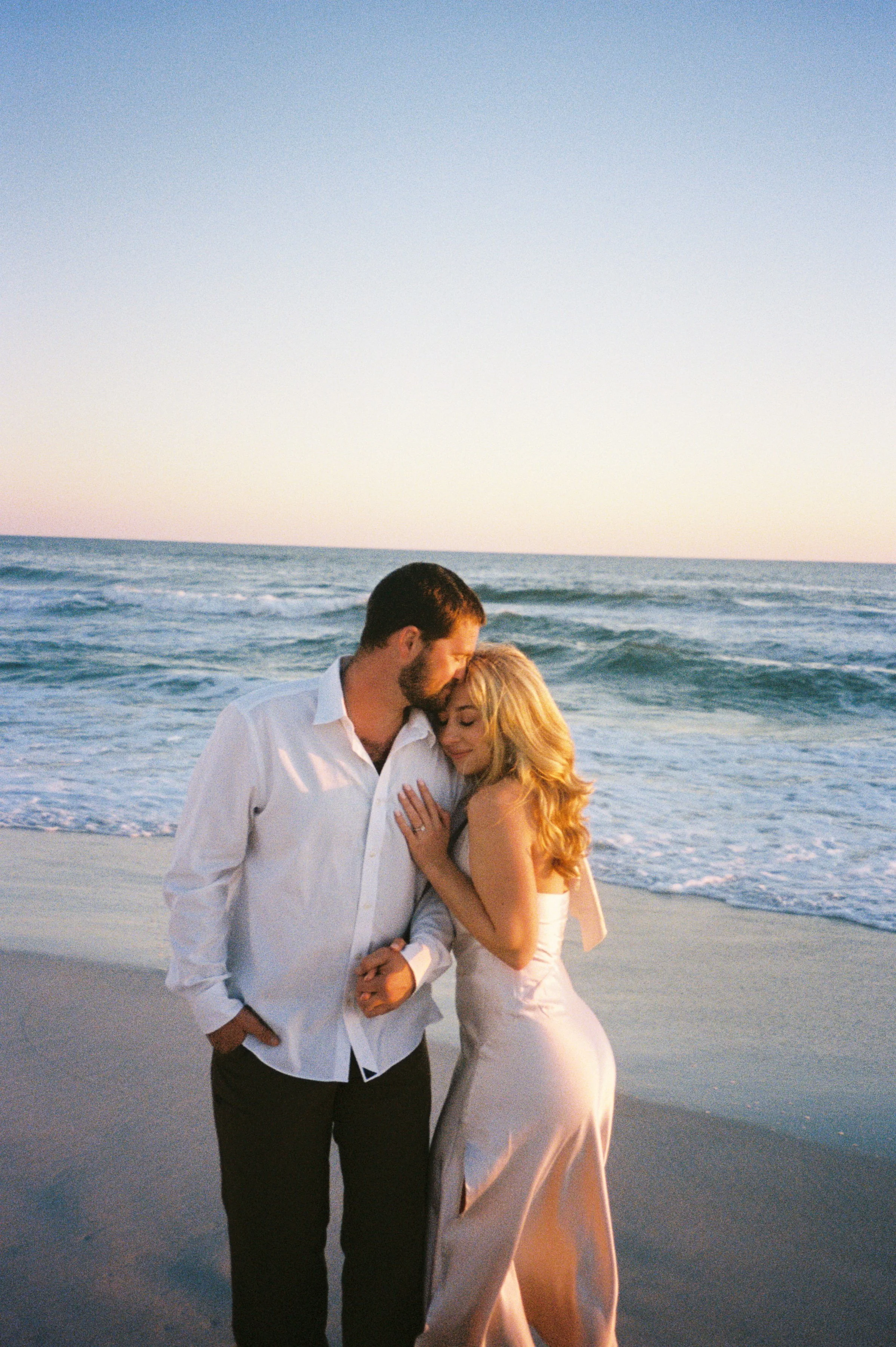 Engagement session on the beach with a couple dressed casually yet elevated