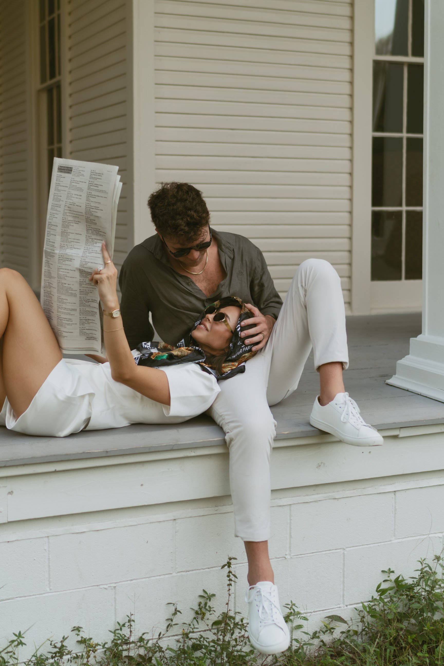 portrait of couple sitting and looking at each other with a magazine
