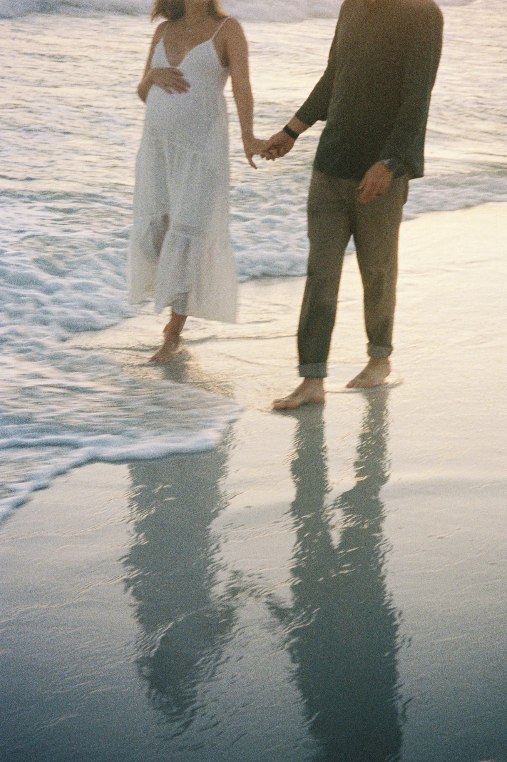 maternity photoshoot on the beach with soft waves