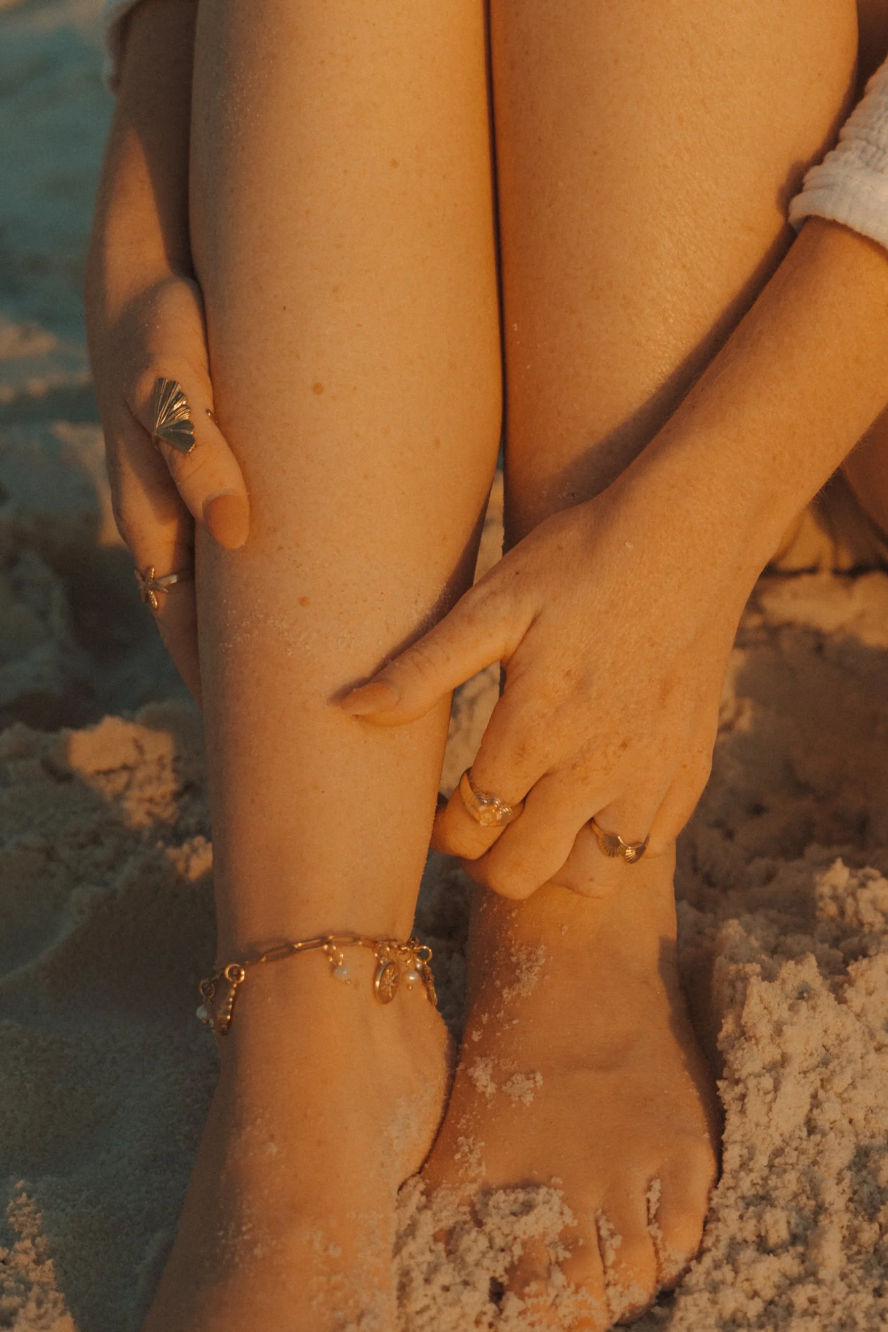 photo showing detail of rings and anklet on the beach