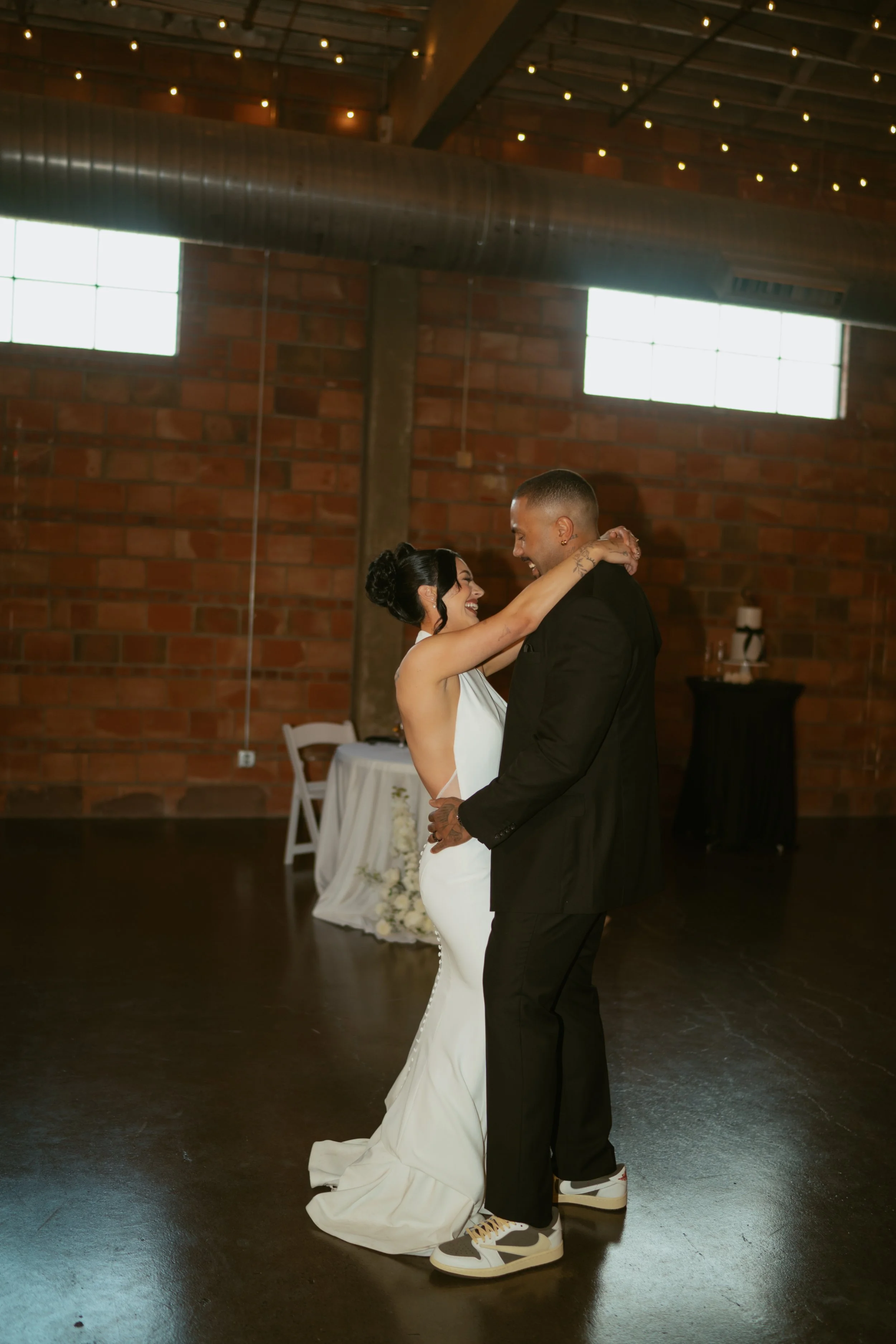  Bride and groom laughing together during first dance  