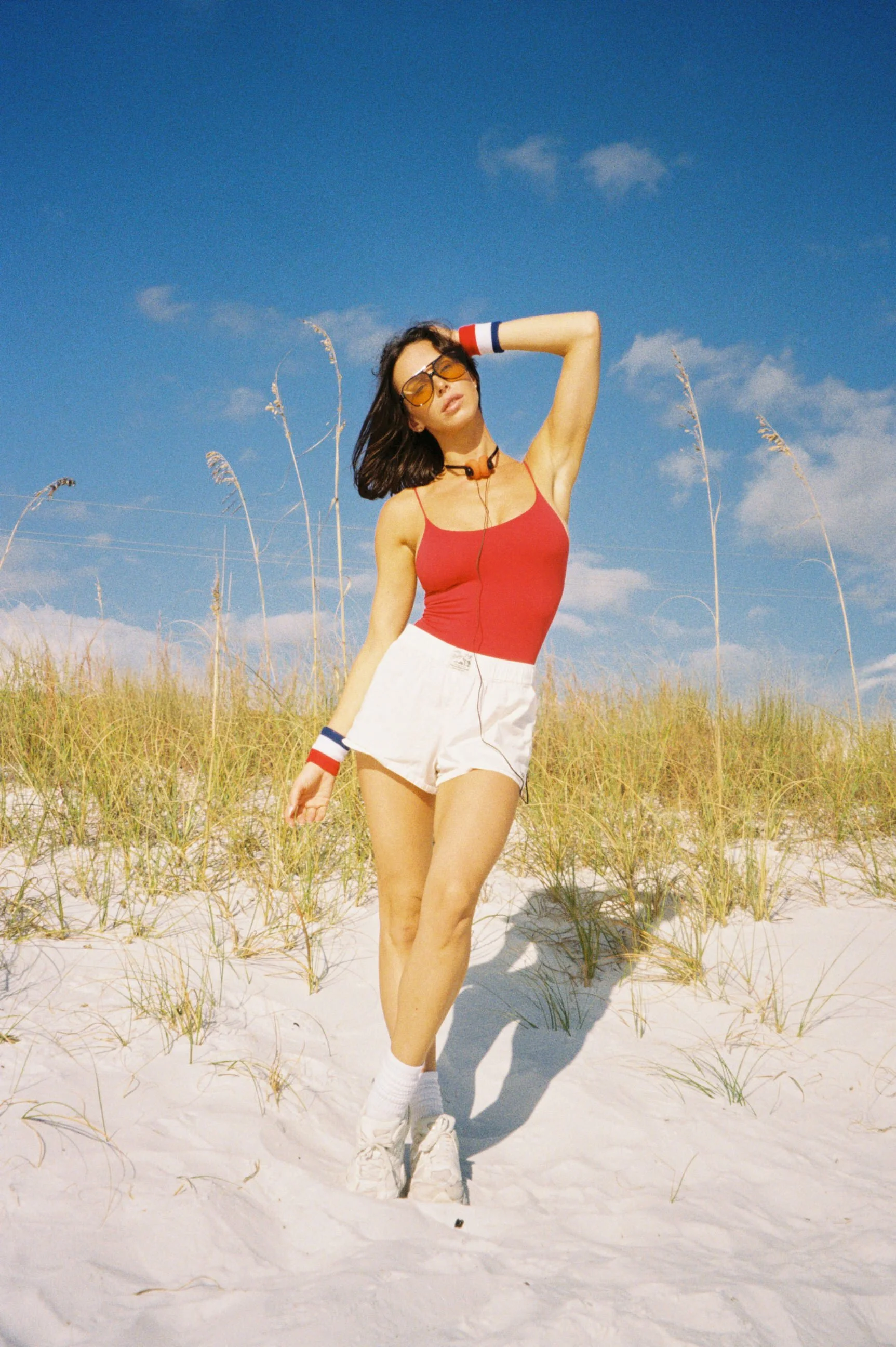 Bold portrait session for brand with pop of red tank top and white shorts 