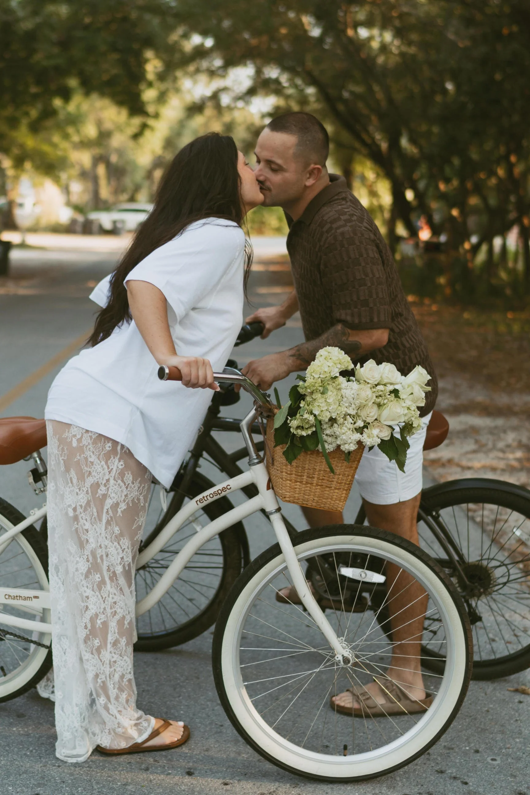 Couple on cute bikes with basket kissing each other